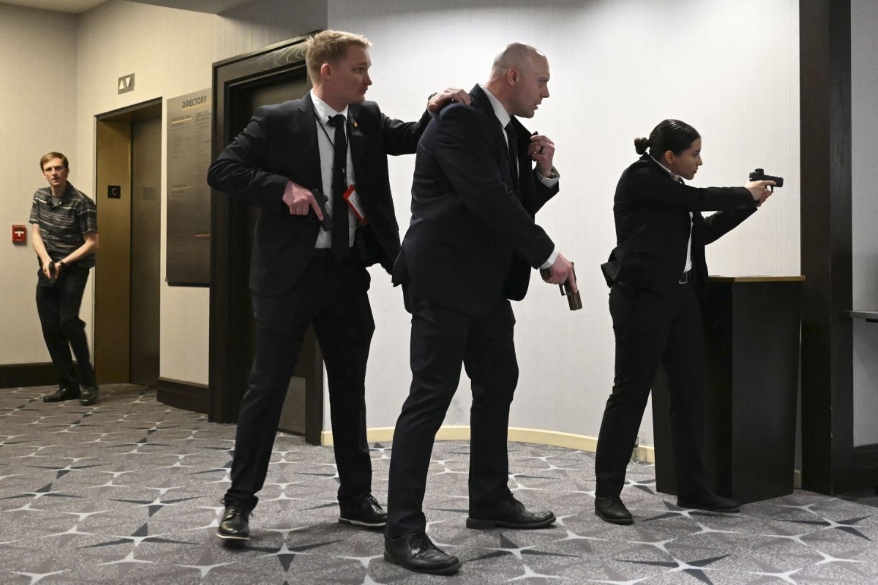 Agentes sacan sus armas después de que se escucharan fuertes golpes durante la cena de los corresponsales de la Casa Blanca en el Washington Hilton en Washington, DC, el 25 de abril de 2026. El presidente Trump asiste a la gala anual de la prensa política por primera vez mientras está en el cargo. (Foto de Mandel NGAN / AFP)
