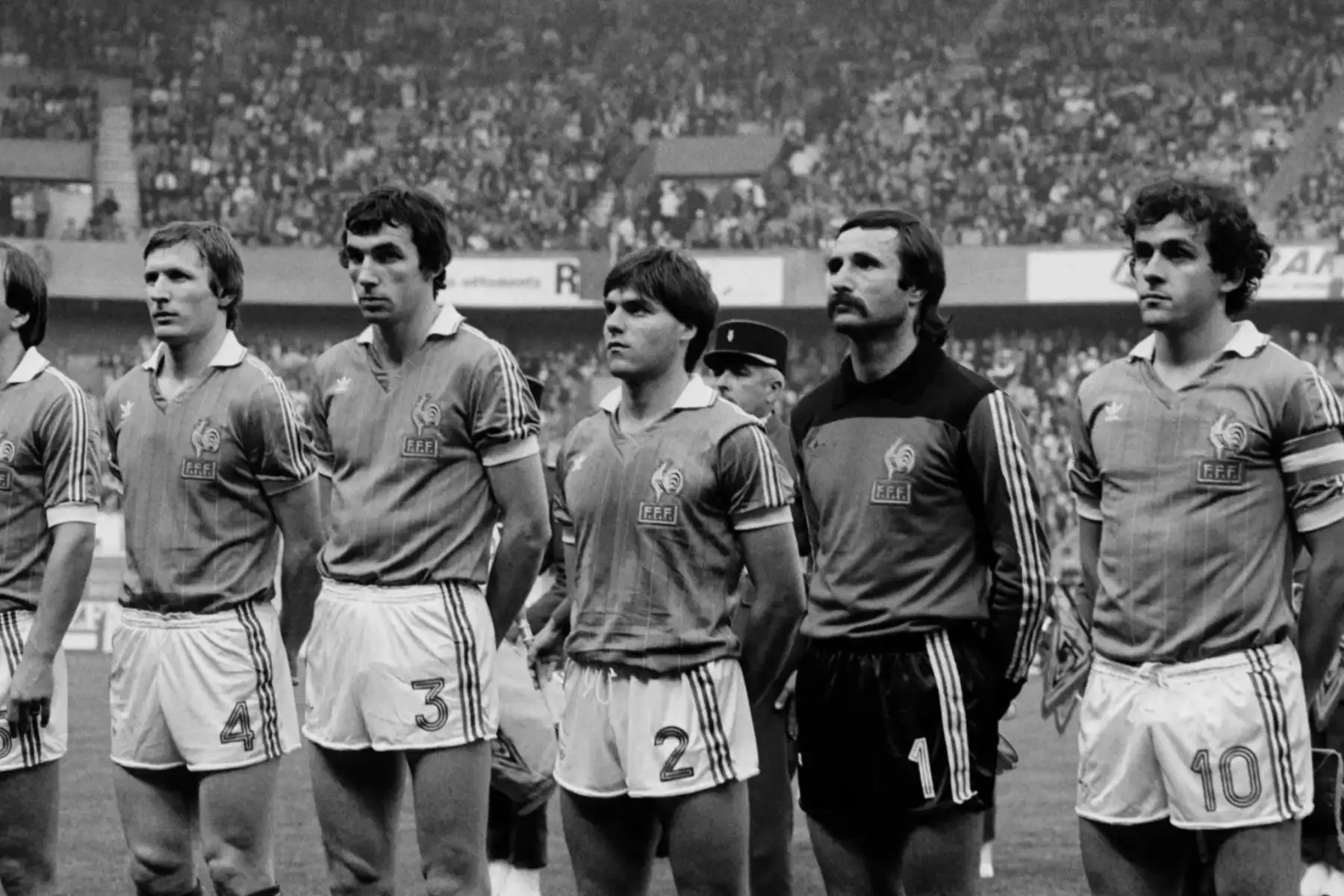 Los jugadores franceses (desde la izquierda), Leonard Specht, Maxime Bossis, Manuel Amoros, Dominique Baratelli y Michel Platini escuchan el himno nacional antes del partido amistoso Francia-Perú en el estadio Parc des Princes en París el 28 de abril de 1982. / AFP