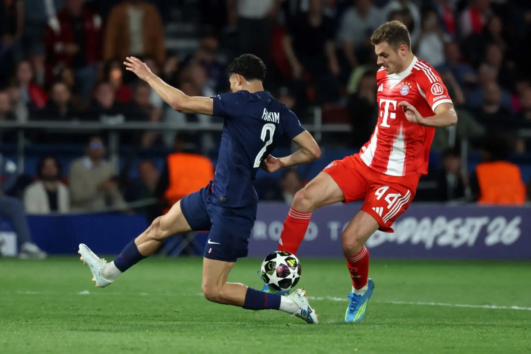 El defensa croata del Bayern de Múnich, Josip Stanisic (número 44), disputa el balón con el defensa marroquí del Paris Saint-Germain, Achraf Hakimi (número 2), durante el partido de ida de las semifinales de la Liga de Campeones de la UEFA entre el Paris Saint-Germain (PSG) y el Bayern de Múnich en el Parque de los Príncipes de París, el 28 de abril de 2026. (Foto de ALAIN JOCARD / AFP)