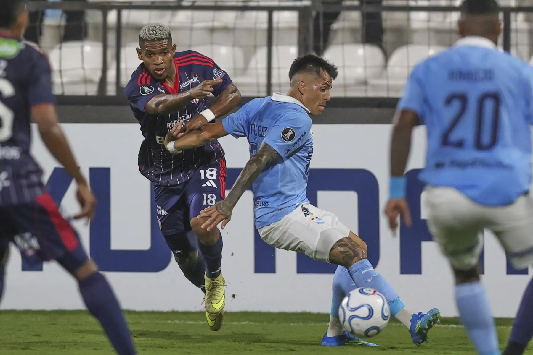 Santiago Gonzáles de Sporting Cristal disputa el balón con el futbolista Kevin Pérez del Junior de Barranquilla, durante el partido de la fecha 2 del Grupo F de la Copa Libertadores, en el Estadio Alejandro Villanueva de Lima. Foto: ANDINA/Carlos Américo Lezama Villantoy