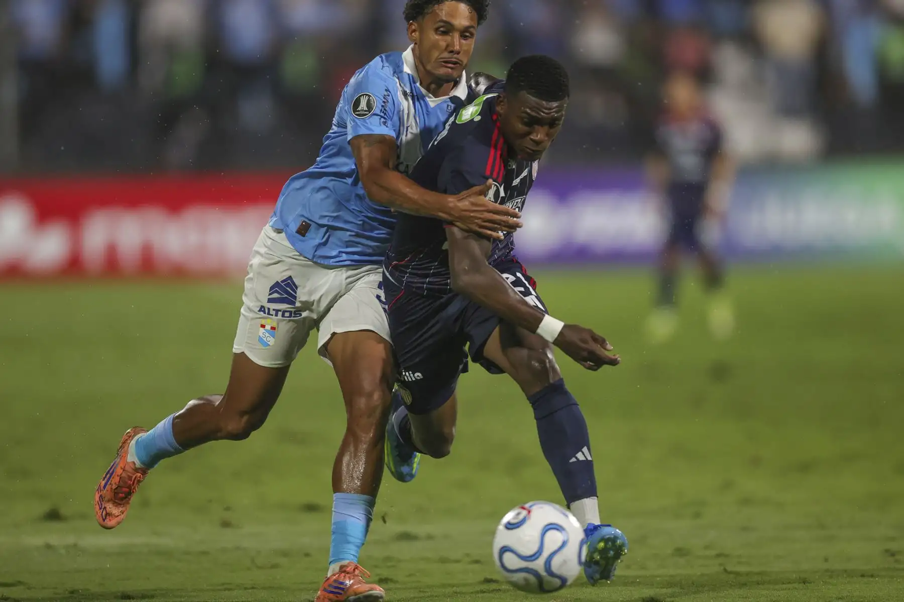 Cristiano da Silva de Sporting Cristal disputa el balón con el futbolista Joel Canchimbo del Junior de Barranquilla, durante el partido de la fecha 2 del Grupo F de la Copa Libertadores, en el Estadio Alejandro Villanueva de Lima. Foto: ANDINA/Carlos Américo Lezama Villantoy.