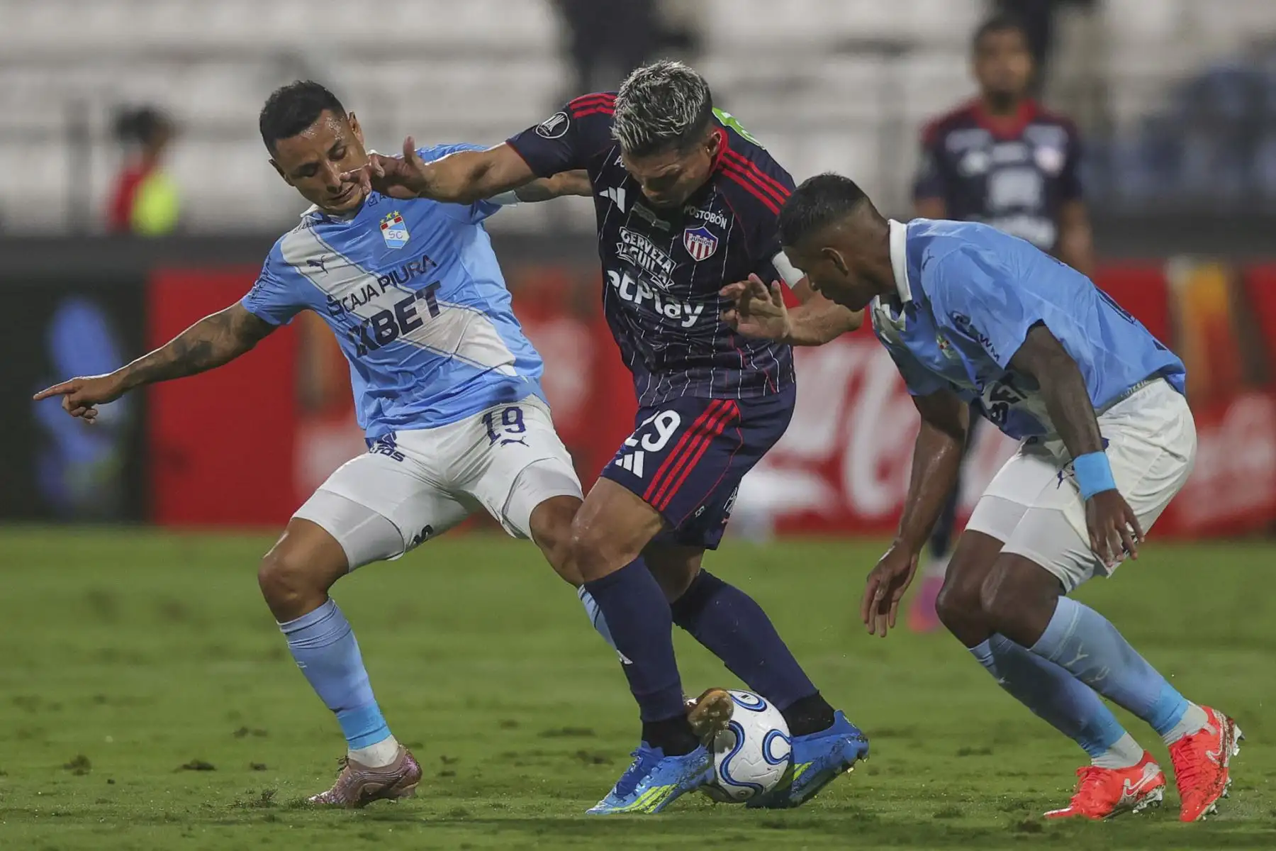 Yoshimar Yotún y Miguel Araujo de Sporting Cristal disputan el balón con el futbolista Teófilo Gutierrez del Junior de Barranquilla, durante el partido de la fecha 2 del Grupo F de la Copa Libertadores, en el Estadio Alejandro Villanueva de Lima. Foto: ANDINA/Carlos Américo Lezama Villantoy.