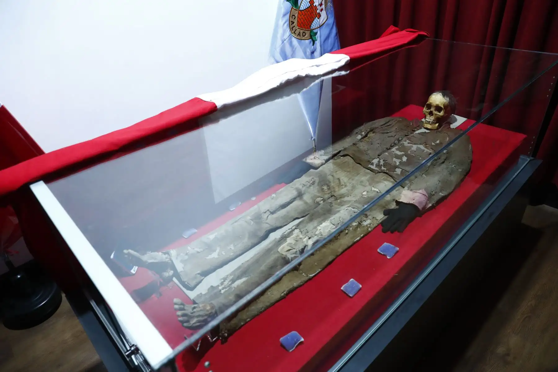 Los restos del soldado desconocido del Callao reposan dentro de una urna de vidrio en el Museo de Historia y Arte del Callao. Personal de laboratorio del museo se encarga de dar mantenimiento al cuerpo y está atento a los cambios temperatura y humedad que podrían afectarlo. Foto: ANDINA/Daniel Bracamonte