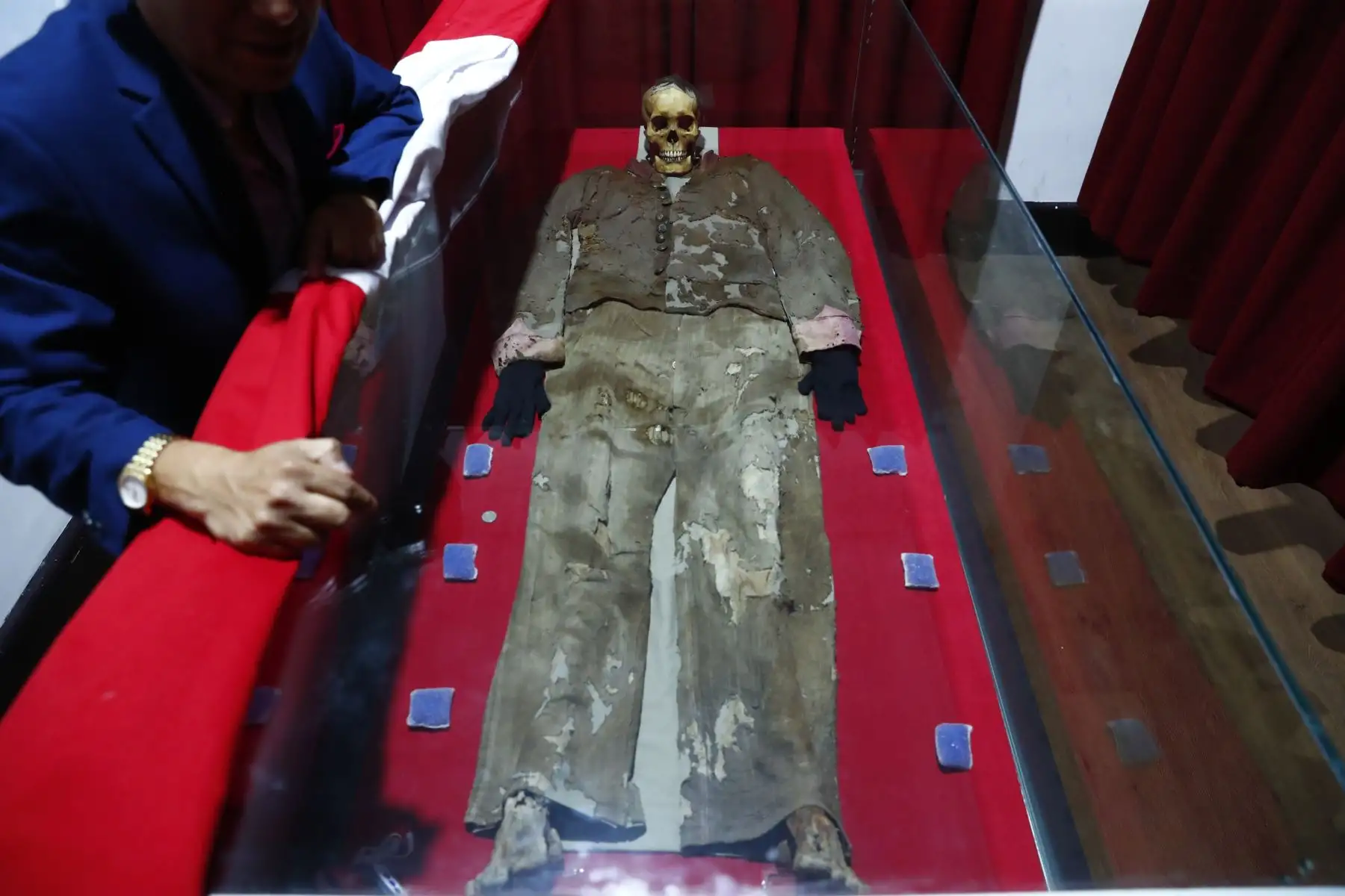 Los restos del soldado desconocido del Callao reposan dentro de una urna de vidrio en el Museo de Historia y Arte del Callao. Personal de laboratorio del museo se encarga de dar mantenimiento al cuerpo y está atento a los cambios temperatura y humedad que podrían afectarlo. Foto: ANDINA/Daniel Bracamonte
