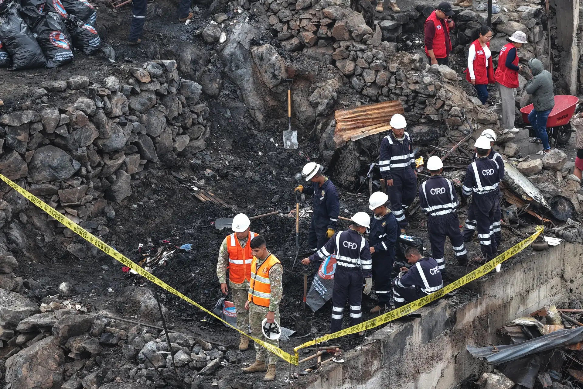 Efectivos de la Policía Nacional, del Ejército, y miembros de Defensa Civil y otras instituciones públicas ayudan en la limpieza y remoción de escombros en la zona afectada por el incendio ocurrido en un cerro del AA.HH. Pampa de Cueva en Independencia el 1 de mayo de 2026. Foto: ANDINA/Daniel Bracamonte