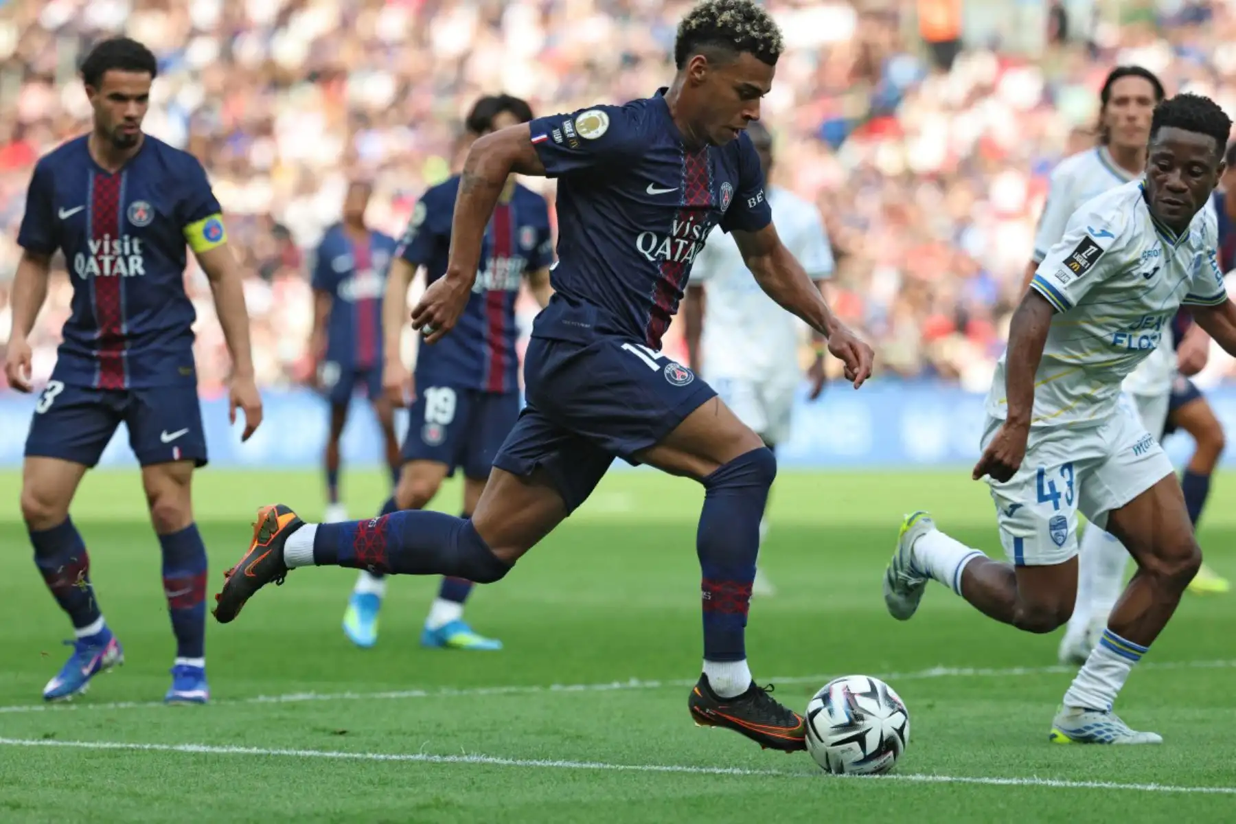 El delantero francés del Paris Saint-Germain, Desire Doue, controla el balón junto al centrocampista burkinés del Lorient, Arsène Kouassi, número 43, durante el partido de la Ligue 1 francesa entre el Paris Saint-Germain (PSG) y el FC Lorient en el estadio Parc des Princes de París. Foto: ANDINA/AFP