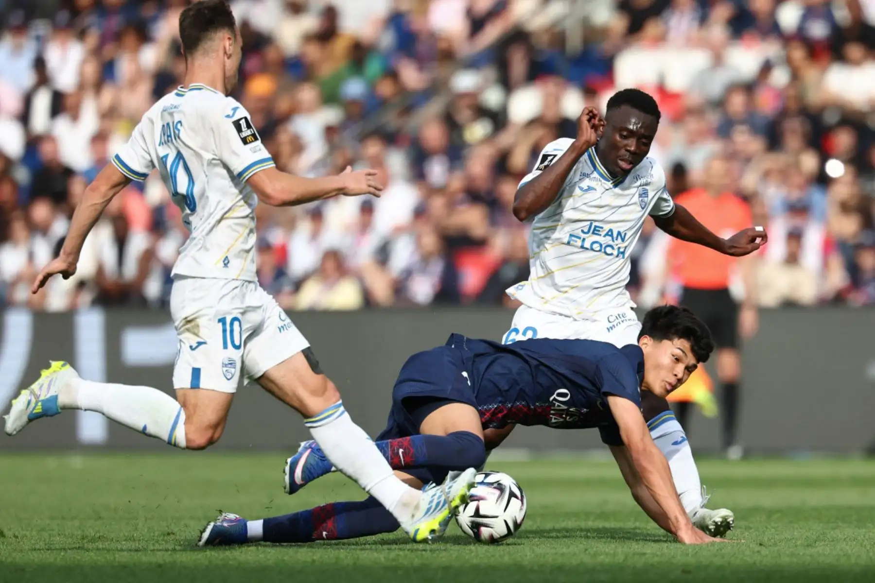 El centrocampista español del Paris Saint-Germain, Dro Fernández, con el número 27, disputa el balón con el centrocampista francés del Lorient, Pablo Pagis, y el centrocampista camerunés Arthur Avom, durante el partido de la Ligue 1 francesa entre el Paris Saint-Germain (PSG) y el FC Lorient en el estadio Parc des Princes de París. Foto: ANDINA/AFP