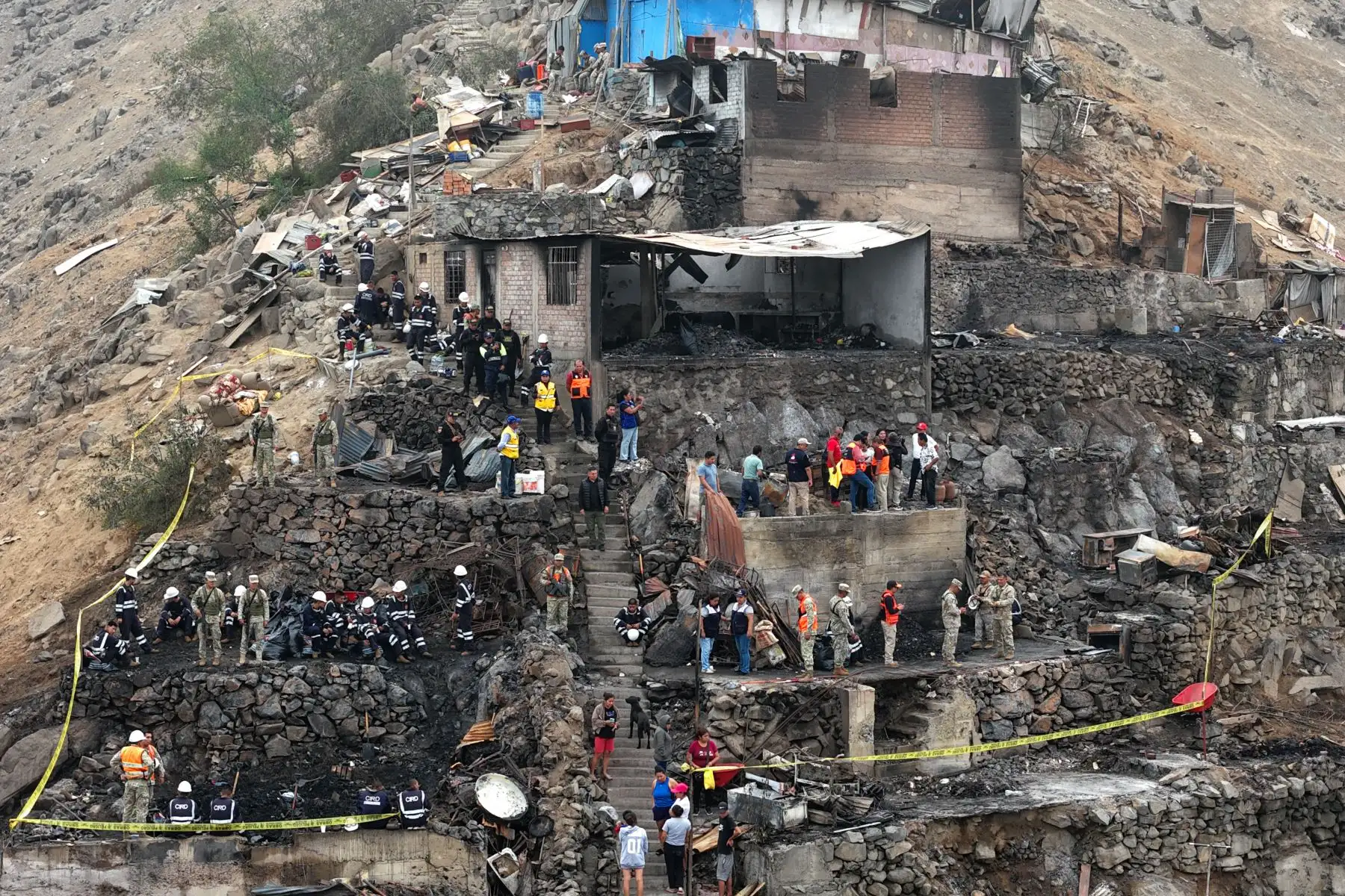 Efectivos de la Policía Nacional, del Ejército, y miembros de Defensa Civil y otras instituciones públicas ayudan en la limpieza y remoción de escombros en la zona afectada por el incendio ocurrido en un cerro del AA.HH. Pampa de Cueva en Independencia el 1 de mayo de 2026. Foto: ANDINA/Daniel Bracamonte
