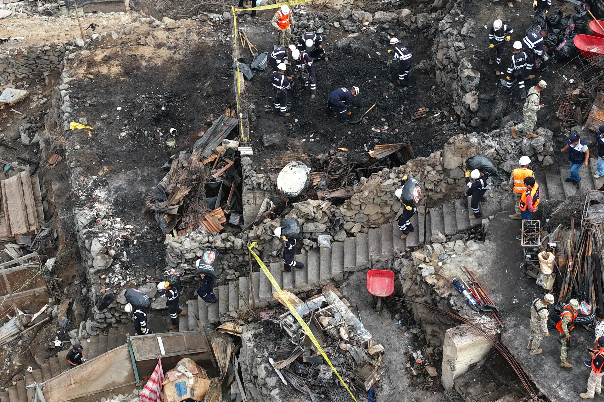 Efectivos de la Policía Nacional, del Ejército, y miembros de Defensa Civil y otras instituciones públicas ayudan en la limpieza y remoción de escombros en la zona afectada por el incendio ocurrido en un cerro del AA.HH. Pampa de Cueva en Independencia el 1 de mayo de 2026. Foto: ANDINA/Daniel Bracamonte