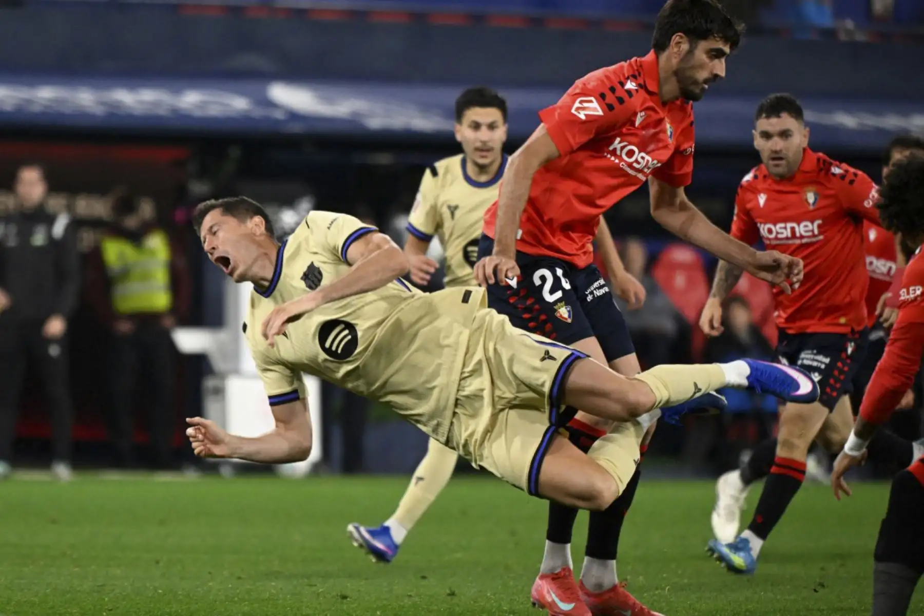 El delantero polaco del Barcelona #09 Robert Lewandowski cae mientras compite por el balón con el defensor español de Osasuna #24 Alejandro Catena durante el partido de fútbol de la liga española entre CA Osasuna y FC Barcelona en el Estadio El Sadar de Pamplona el 2 de mayo de 2026. (Foto de ANDER GILLENEA / AFP)