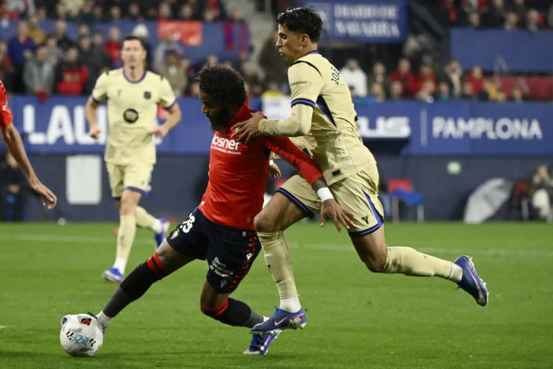El defensor francés de Osasuna #19 Valentin Rosier (L) y el defensor portugués del Barcelona #02 Joao Cancelo luchan por el balón durante el partido de fútbol de la liga española entre el CA Osasuna y el FC Barcelona en el Estadio El Sadar de Pamplona el 2 de mayo de 2026. (Foto de ANDER GILLENEA / AFP)