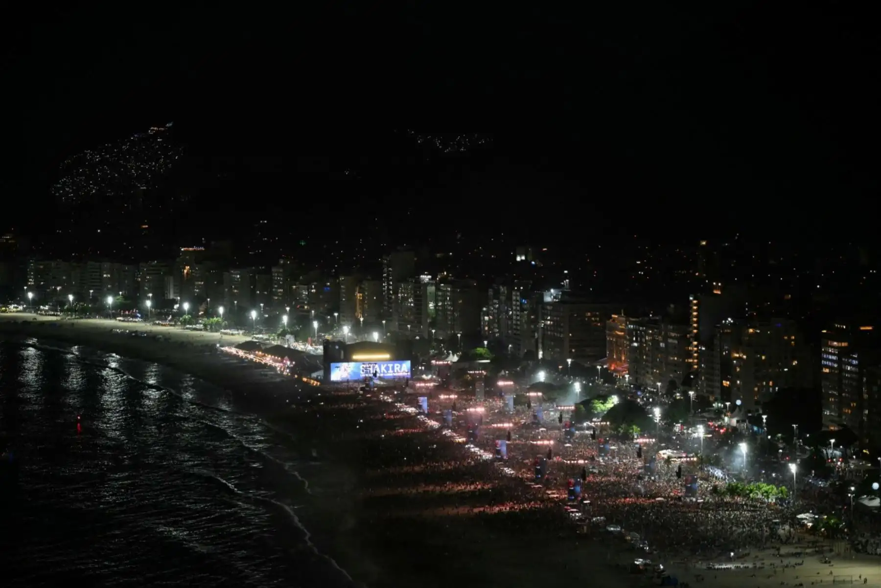 Los fans se reúnen mientras DJ Vintage Culture actúa antes del concierto de la cantante colombiana Shakira en la playa de Copacabana en Río de Janeiro, Brasil, el 2 de mayo de 2026. (Foto de Daniel RAMALHO / AFP)