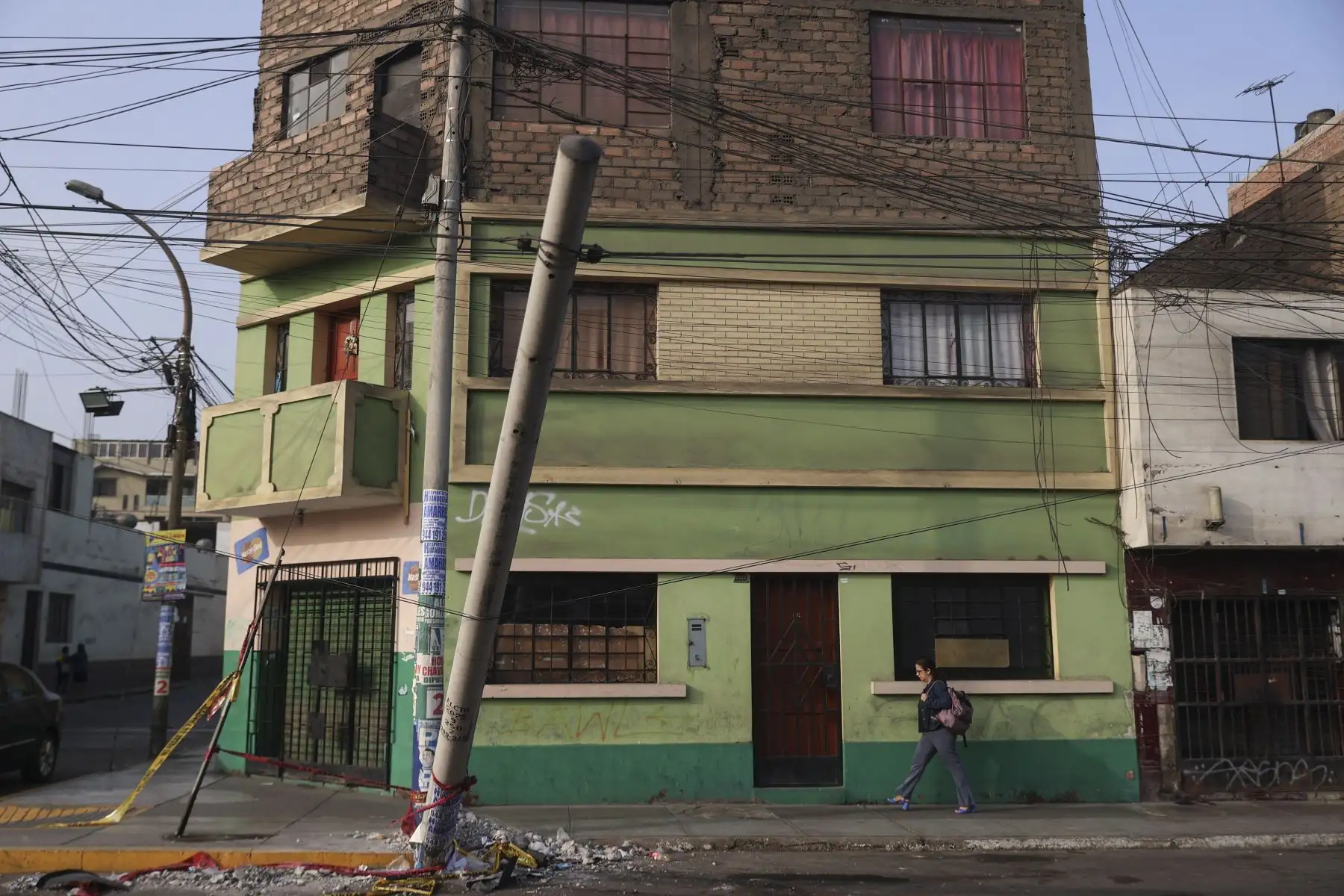 Un poste permanece en plena vía, sostenido únicamente por cables, en la cuadra 28 de la avenida Perú, en San Martín de Porres, situación que ha generado la preocupación de los vecinos, quienes exigen su retiro inmediato. Foto: ANDINA/Jhonel Rodríguez Robles