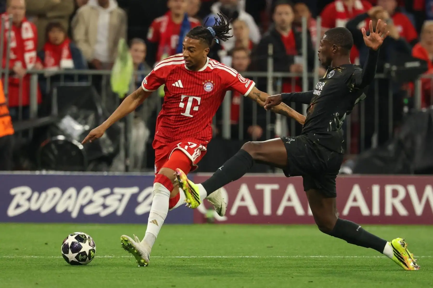 El centrocampista francés del Bayern de Múnich, Michael Olise  y el defensa ecuatoriano del Paris Saint-Germain, Willian Pacho,  disputan el balón durante el partido de vuelta de las semifinales de la Liga de Campeones de la UEFA entre el FC Bayern de Múnich y el Paris Saint-Germain. Foto: AFP