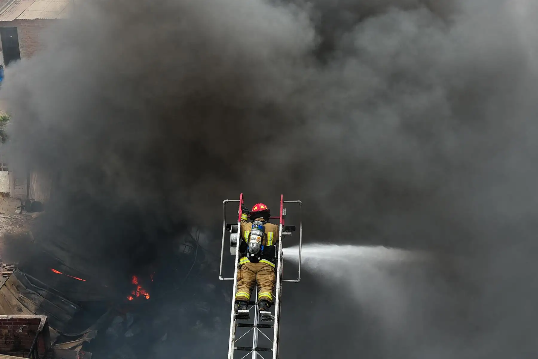 El incendio, presuntamente originado en un almacén con productos químicos y materiales inflamables, mantiene en alerta a vecinos y autoridades de Villa El Salvador. Foto: ANDINA/ Juan Carlos Guzmán
