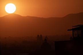 El sol sale tras las montañas al amanecer en la Ciudad de México, imagen de abril de 2026. Foto: AFP