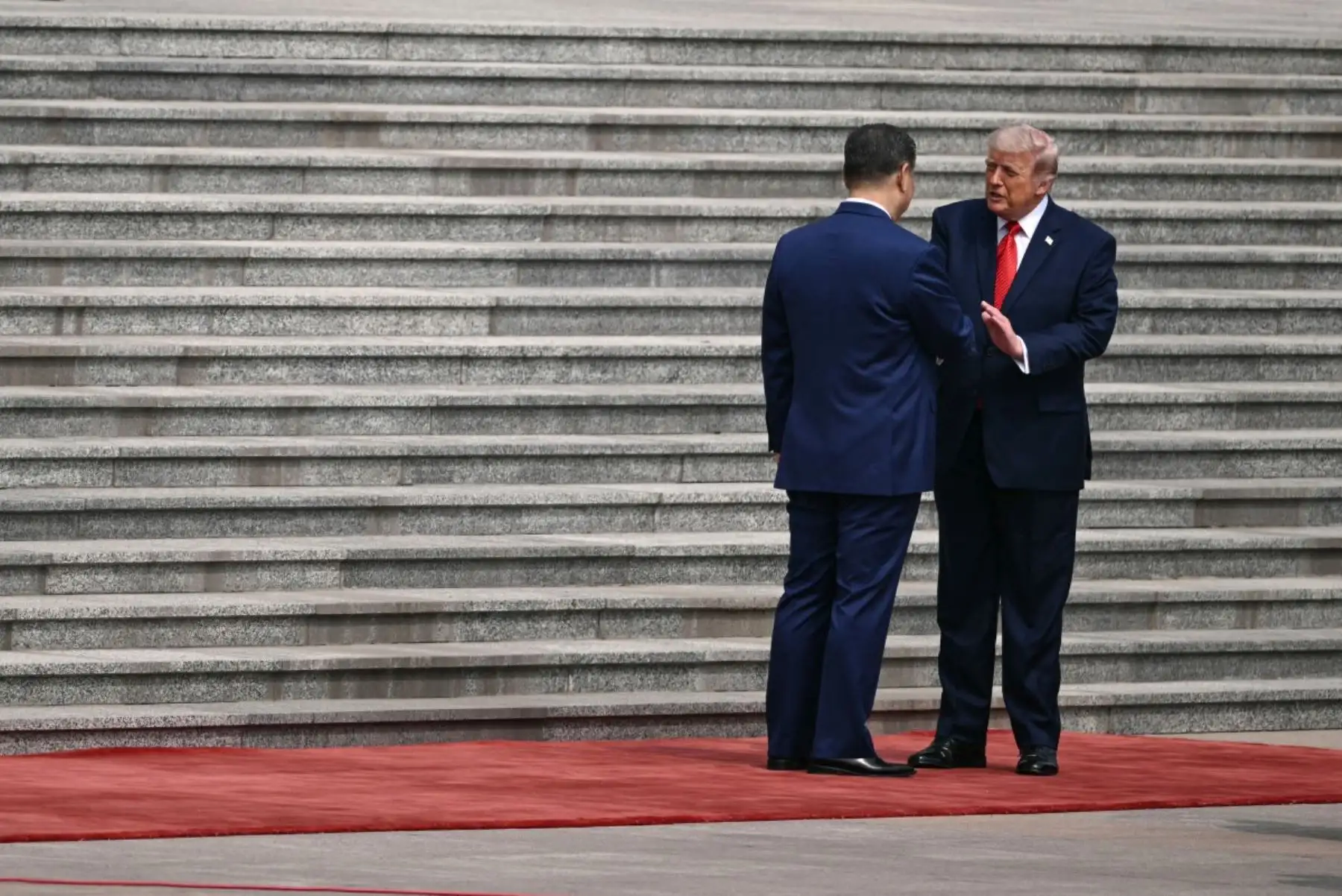 El presidente de Estados Unidos, Donald Trump, estrecha la mano del presidente de China, Xi Jinping, durante una ceremonia de bienvenida en el Gran Salón del Pueblo en Pekín el 14 de mayo de 2026. Foto: AFP