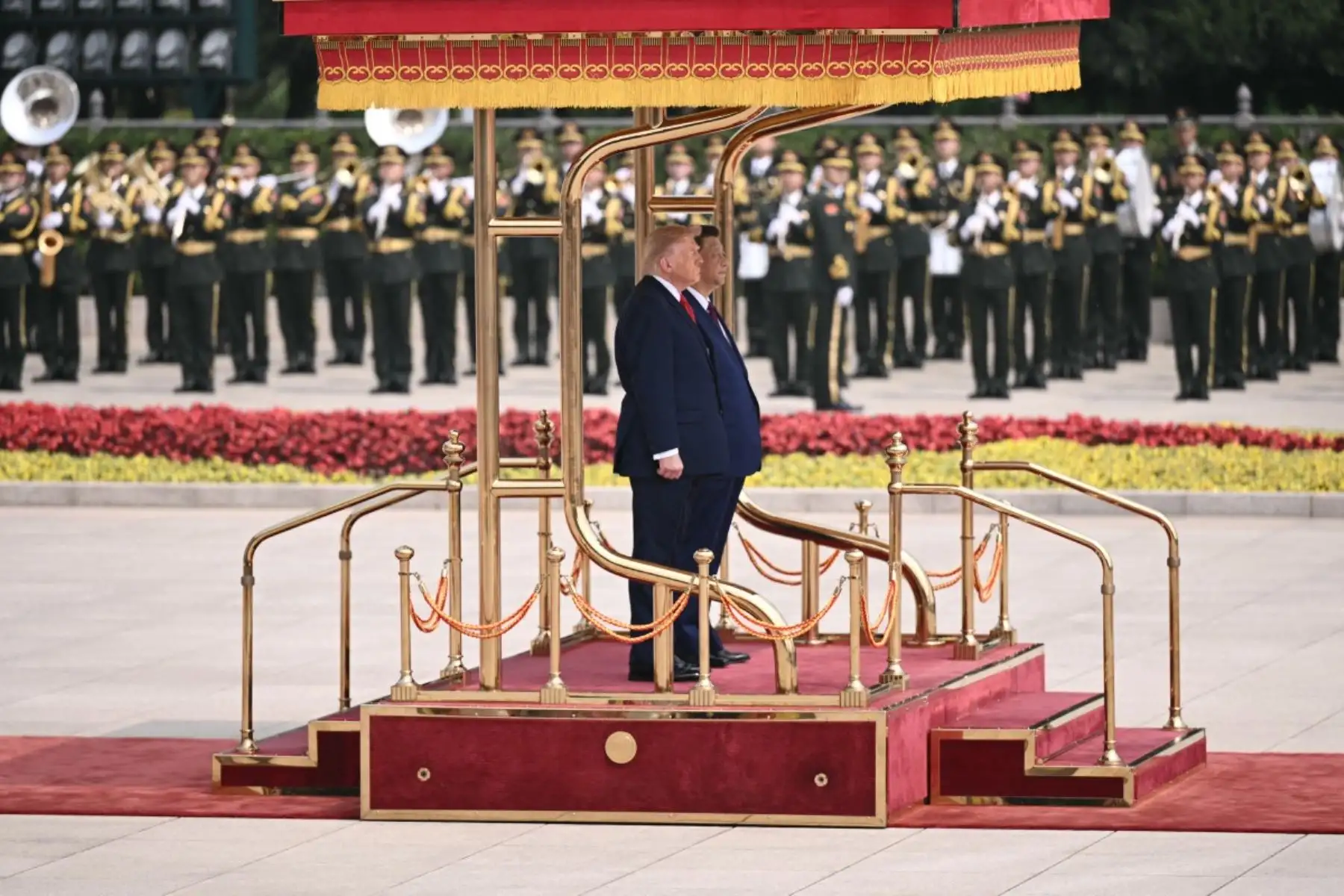 El presidente de Estados Unidos, Donald Trump, y el presidente de China, Xi Jinping, se ponen de pie para escuchar los himnos nacionales de sus respectivos países durante la ceremonia de bienvenida en el Gran Salón del Pueblo en Beijing el 14 de mayo de 2026. Foto: AFP