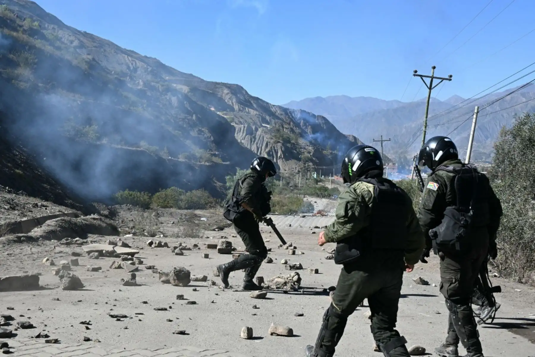 Los agentes de policía antidisturbios retiran rocas de una carretera bloqueada por manifestantes rurales en Lipari, departamento de La Paz, Bolivia, el 16 de mayo de 2026. El gobierno de Bolivia llegó a un acuerdo el 15 de mayo con miles de mineros que se enfrentaron a la policía en una protesta que paralizó el centro de La Paz. Sin embargo, otros sectores continúan bloqueando las rutas de acceso a la ciudad, hogar del poder ejecutivo y el Congreso. (Foto de AIZAR RALDES / AFP)
