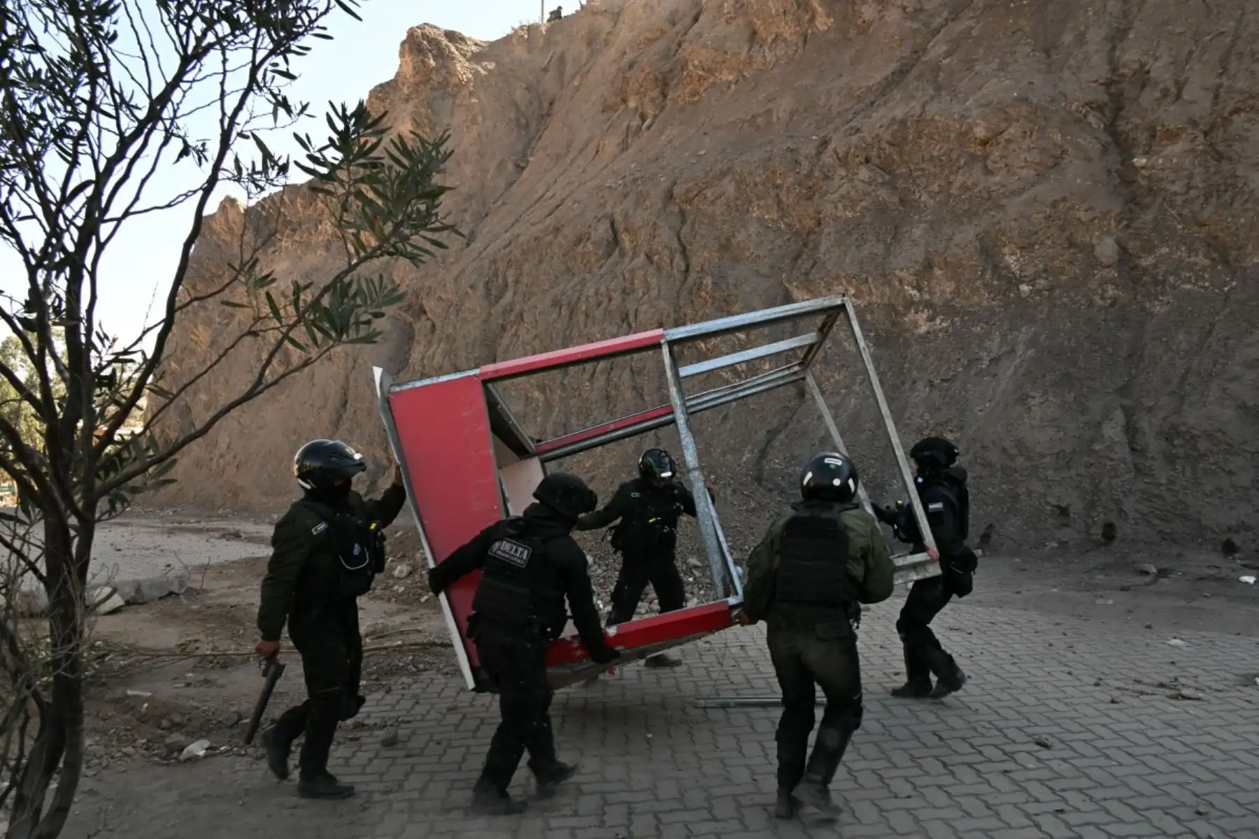 Los agentes de la policía antidisturbios limpian los escombros de una carretera durante los enfrentamientos con manifestantes rurales en Lipari, departamento de La Paz, Bolivia, el 16 de mayo de 2026. El gobierno de Bolivia llegó a un acuerdo el 15 de mayo con miles de mineros que se enfrentaron a la policía en una protesta que paralizó el centro de La Paz. Sin embargo, otros sectores continúan bloqueando las rutas de acceso a la ciudad, hogar del poder ejecutivo y el Congreso. (Foto de AIZAR RALDES / AFP)