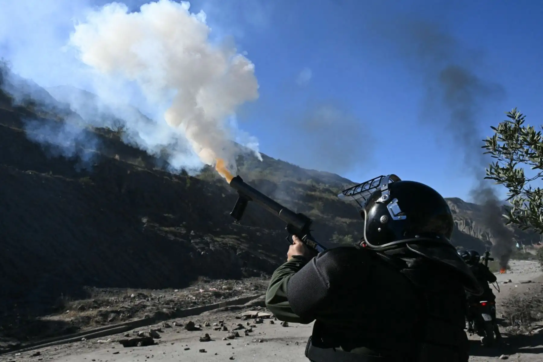 La policía antidisturbios dispara gases lacrimógenos contra manifestantes rurales que bloquean una carretera en Lipari, departamento de La Paz, Bolivia, el 16 de mayo de 2026. El gobierno de Bolivia llegó a un acuerdo el 15 de mayo con miles de mineros que se enfrentaron a la policía en una protesta que paralizó el centro de La Paz. Sin embargo, otros sectores continúan bloqueando las rutas de acceso a la ciudad, hogar del poder ejecutivo y el Congreso. (Foto de AIZAR RALDES / AFP)
