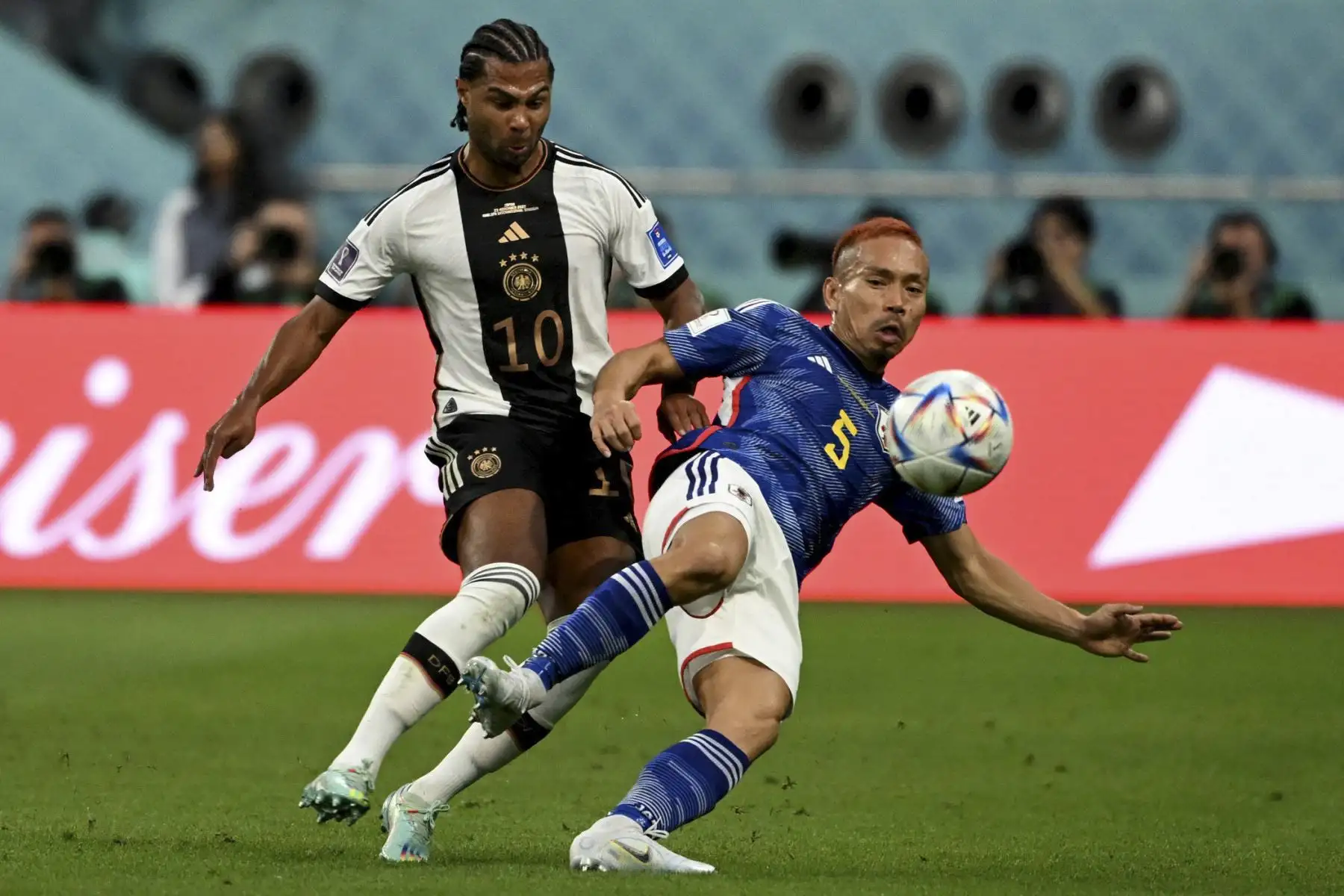 El delantero alemán #10 Serge Gnabry y el defensor japonés #05 Yuto Nagatomo luchan por el balón durante el partido de fútbol del Grupo E de la Copa Mundial de Qatar 2022 entre Alemania y Japón en el Estadio Internacional Khalifa en Doha el 23 de noviembre de 2022. (Foto de INA FASSBENDER / AFP)