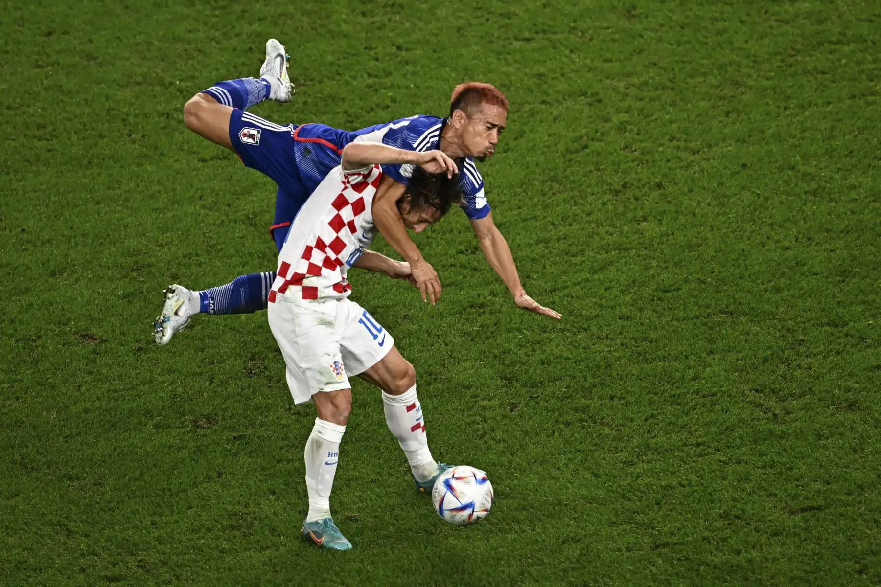 El centrocampista de Croacia #10 Luka Modric y el defensor de Japón #05 Yuto Nagatomo luchan por el balón durante el partido de octavos de partido de fútbol de la Copa Mundial de Qatar 2022 entre Japón y Croacia en el Estadio Al-Janoub en Al-Wakrah, al sur de Doha, el 5 de diciembre de 2022. (Foto de Anne-Christine POUJOULAT / AFP)