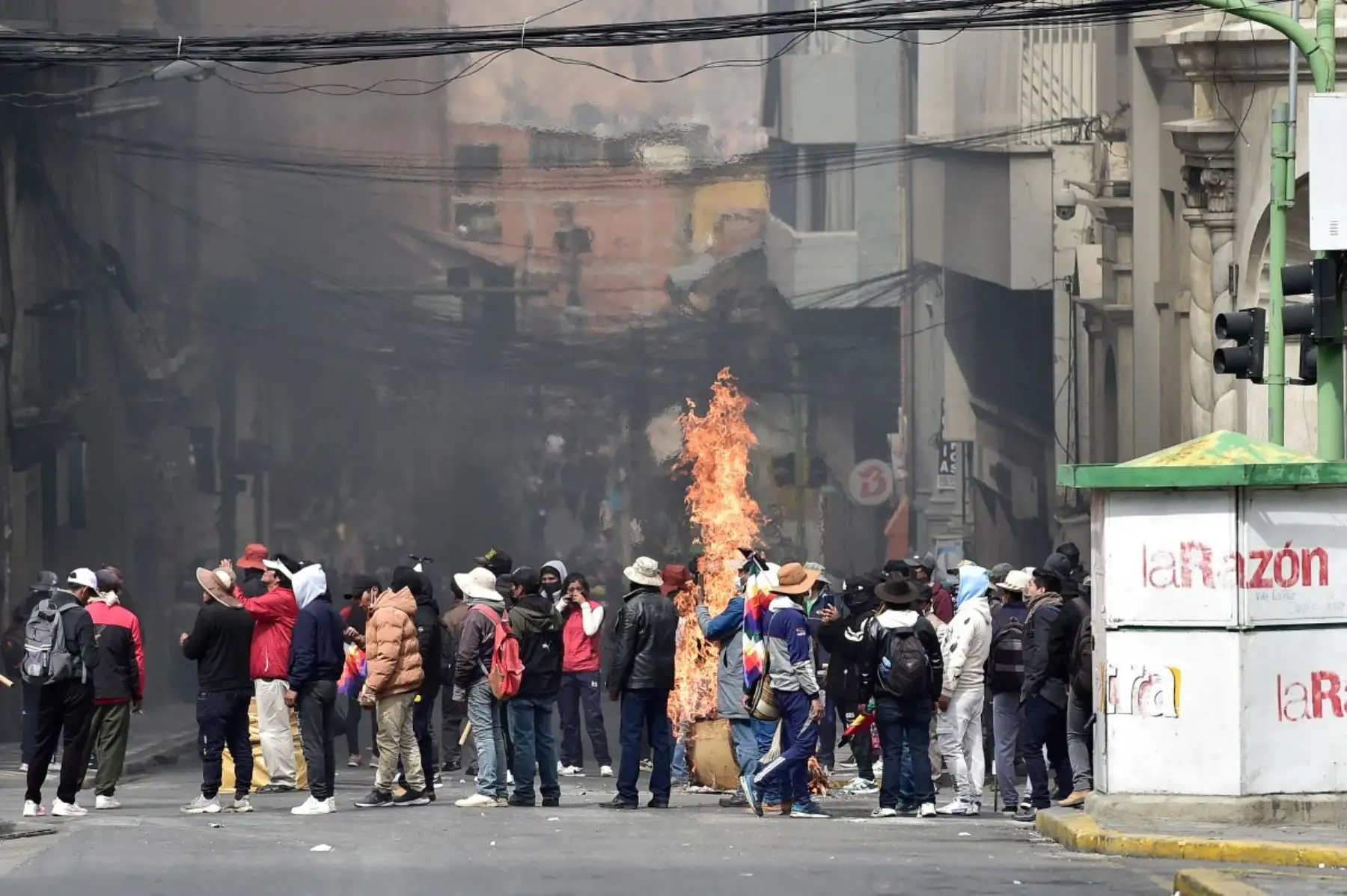 Las llamas se levantan de una caja de cartón mientras los mineros se enfrentan a la policía antidisturbios durante una protesta que exige la renuncia del presidente boliviano Rodrigo Paz, en La Paz. Foto: AFP