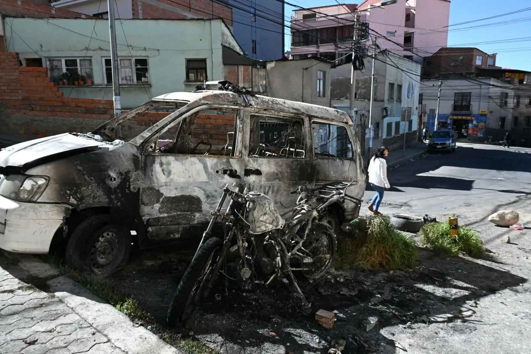 Vista de un coche y una motocicleta de policía quemados en La Paz, el 19 de mayo de 2026, el día después de una protesta exigiendo la renuncia del presidente de Bolivia, Rodrigo Paz. Las protestas bolivianas que piden que el presidente de centro-derecha Rodrigo Paz renuncie se intensificaron. Foto: AFP