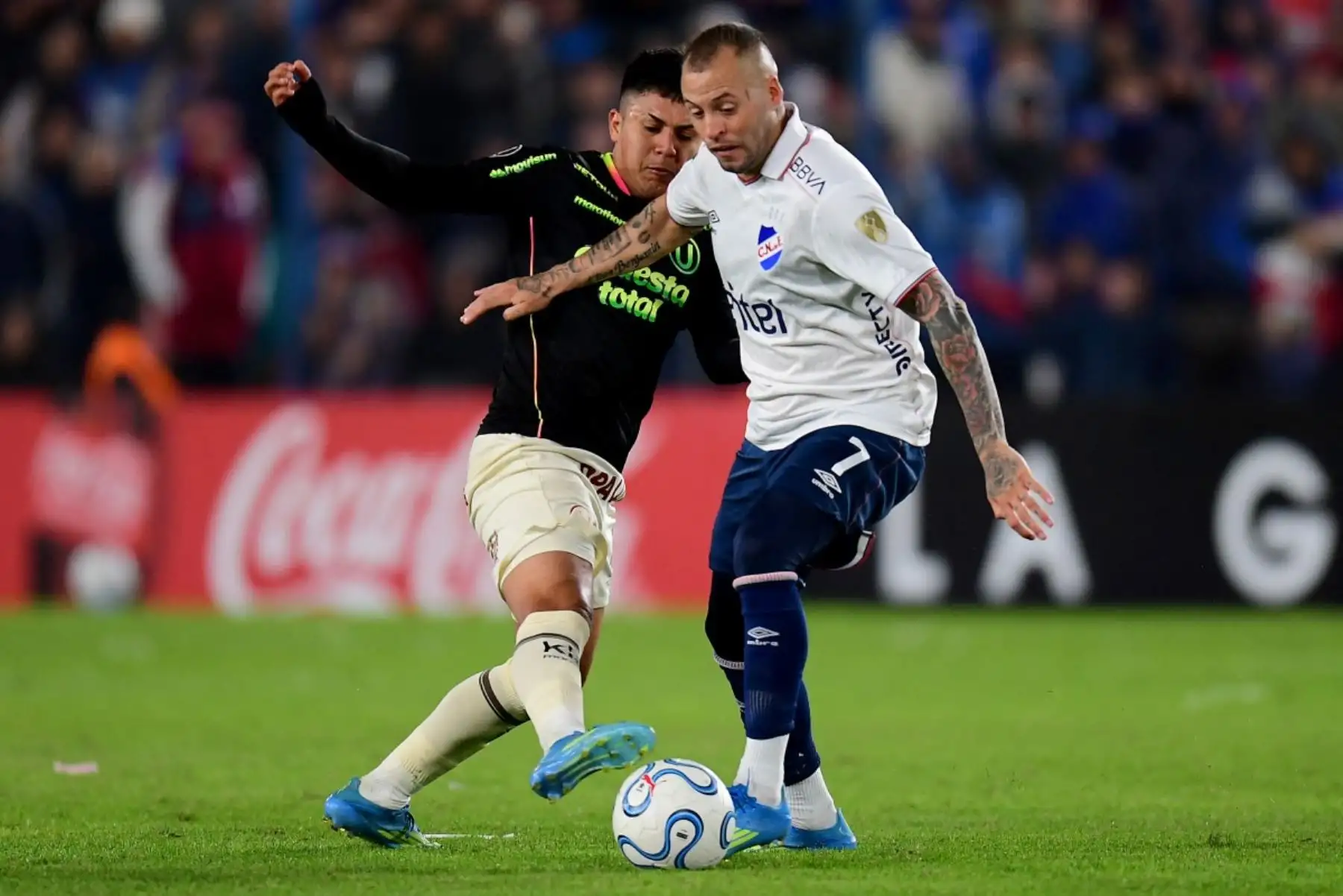 El mediocampista de Universitario  Jairo Concha  y el mediocampista de Nacional Nicolás López luchan por el balón durante el partido de fútbol de la fase de grupos de la Copa Libertadores entre Nacional de Uruguay y Universitario de Perú. AFP
