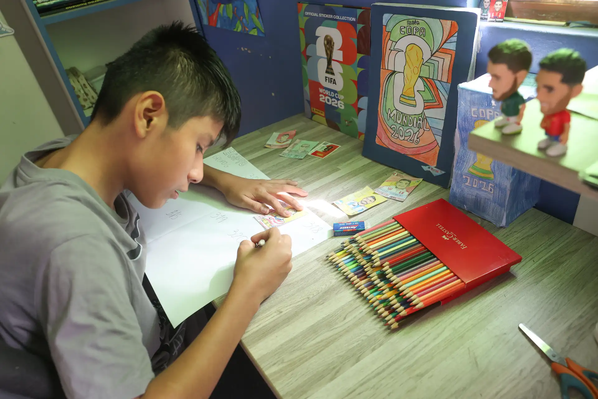 El menor dedica parte de su tiempo libre a dibujar y colorear las figuras de futbolistas que integran su álbum inspirado en el Mundial FIFA 2026. Foto: ANDINA/Melina Mejía.