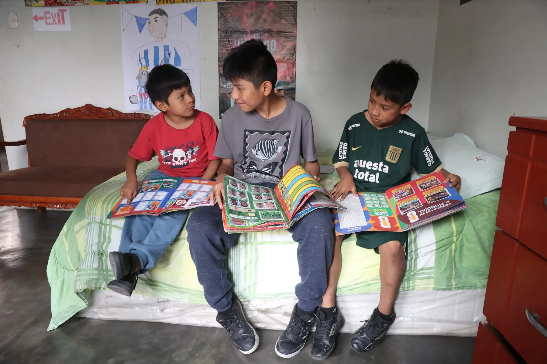 Mathías comparte su afición por el fútbol junto a otros niños mientras revisan parte del álbum que creó inspirado en la próxima Copa del Mundo. Foto: ANDINA/Melina Mejía.