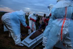 Personal médico con equipos de protección individual (EPI) entierra a un paciente fallecido en el hospital de Rwampara, el 21 de mayo. Foto: AFP