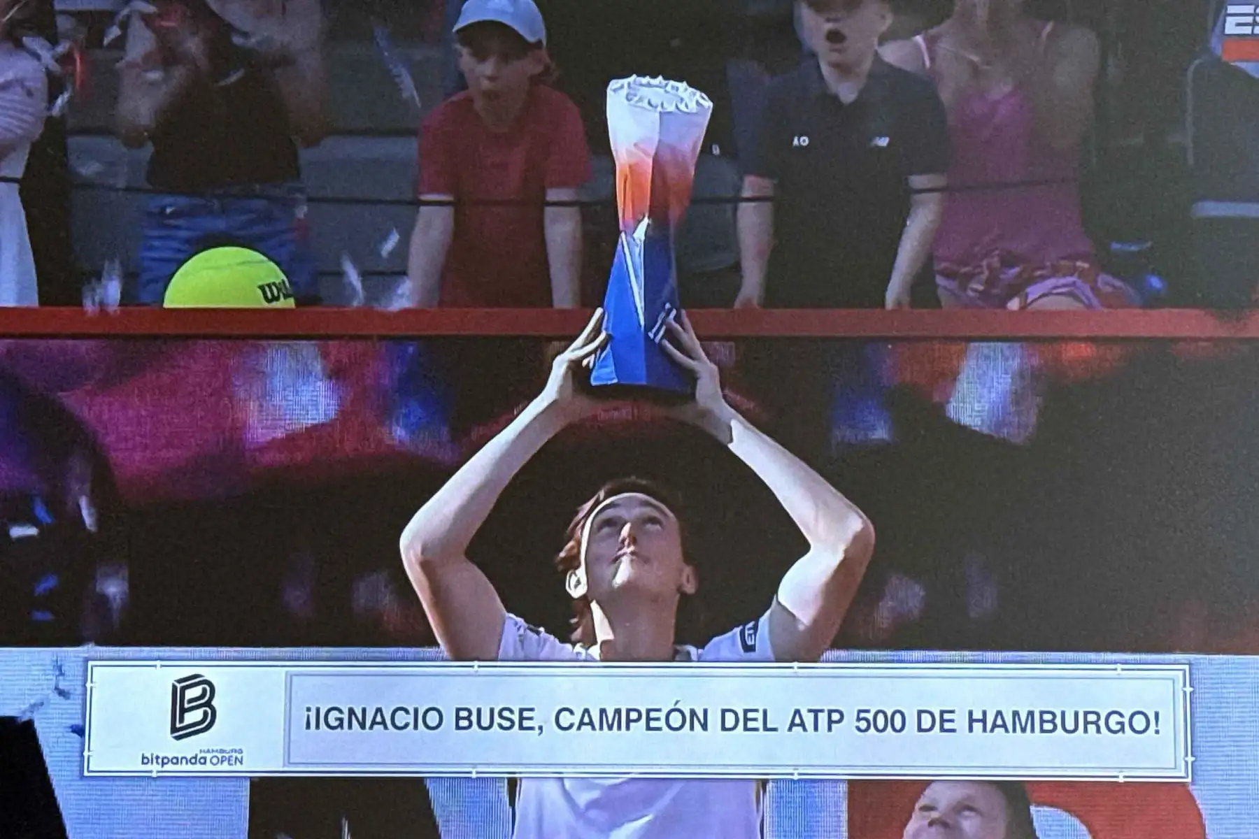 El peruano Ignacio Buse levanta el trofeo de campeón en Hamburgo luego de firmar una histórica actuación que lo consolida como una de las grandes promesas del tenis nacional. Foto: ANDINA/Captura TV