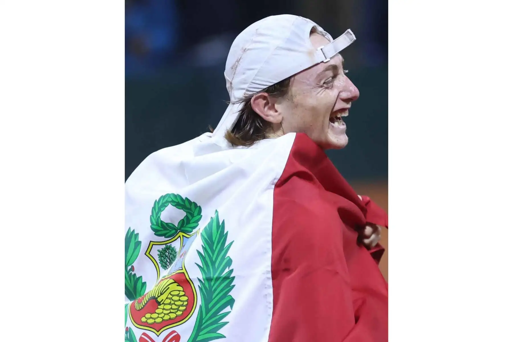 Ignacio Buse sonríe mientras luce la bandera peruana tras conquistar el torneo de Hamburgo y devolver al Perú un título internacional de tenis luego de 19 años. Foto: ANDINA.