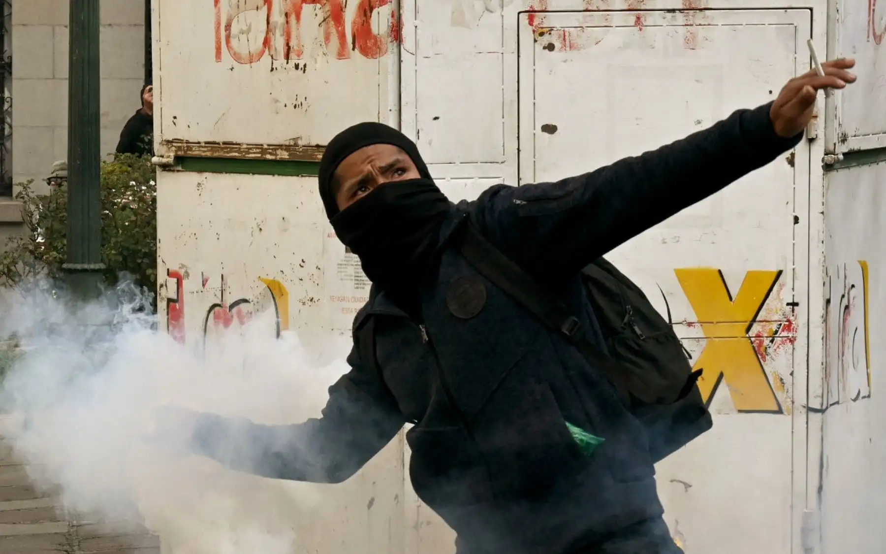 Un manifestante lanza un objeto durante los enfrentamientos con la policía en La Paz, en una nueva jornada de tensión social provocada por la crisis económica y los reclamos contra el gobierno boliviano. Foto: AFP.