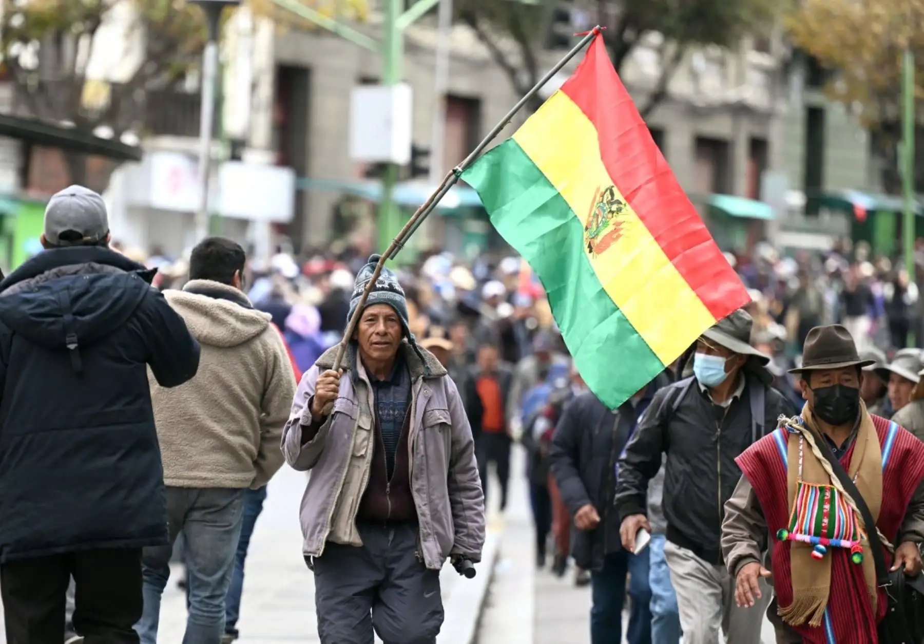 Una manifestante porta la bandera boliviana durante las protestas desarrolladas en La Paz, donde organizaciones sociales y sindicatos demandaron aumentos salariales y soluciones ante la escasez de combustible y alimentos. Foto: AFP.