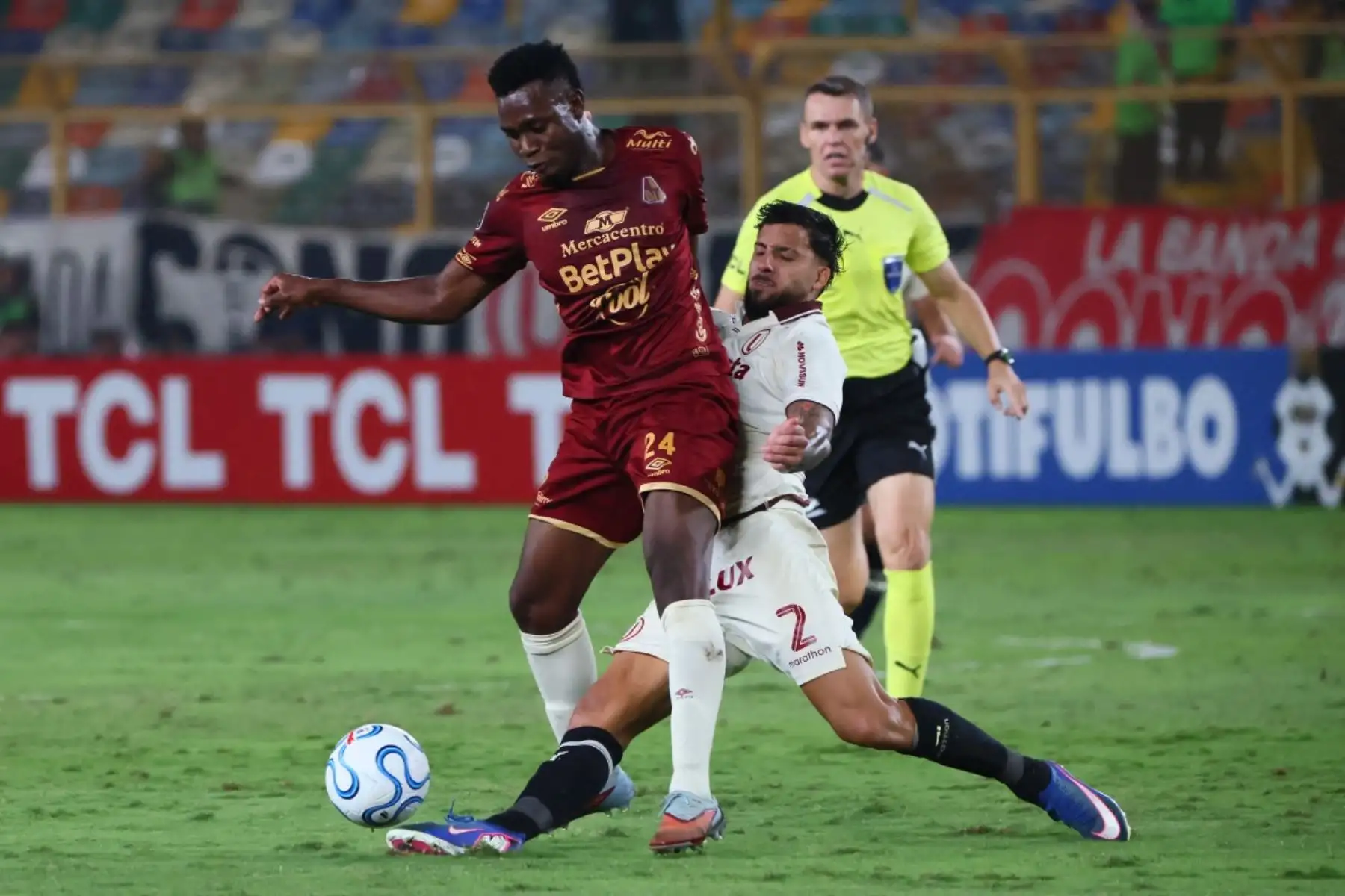 El delantero número 24 del Tolima, Adrián Parra, y el defensa argentino número 02 del Universitario, Caín Fara, luchan por el balón durante el partido de la fase de grupos de la Copa Libertadores entre el Universitario de Perú y el Deportes Tolima de Colombia en el Estadio Monumental "U" Marathon de Lima, el 26 de mayo de 2026. (Foto de Connie FRANCE / AFP)