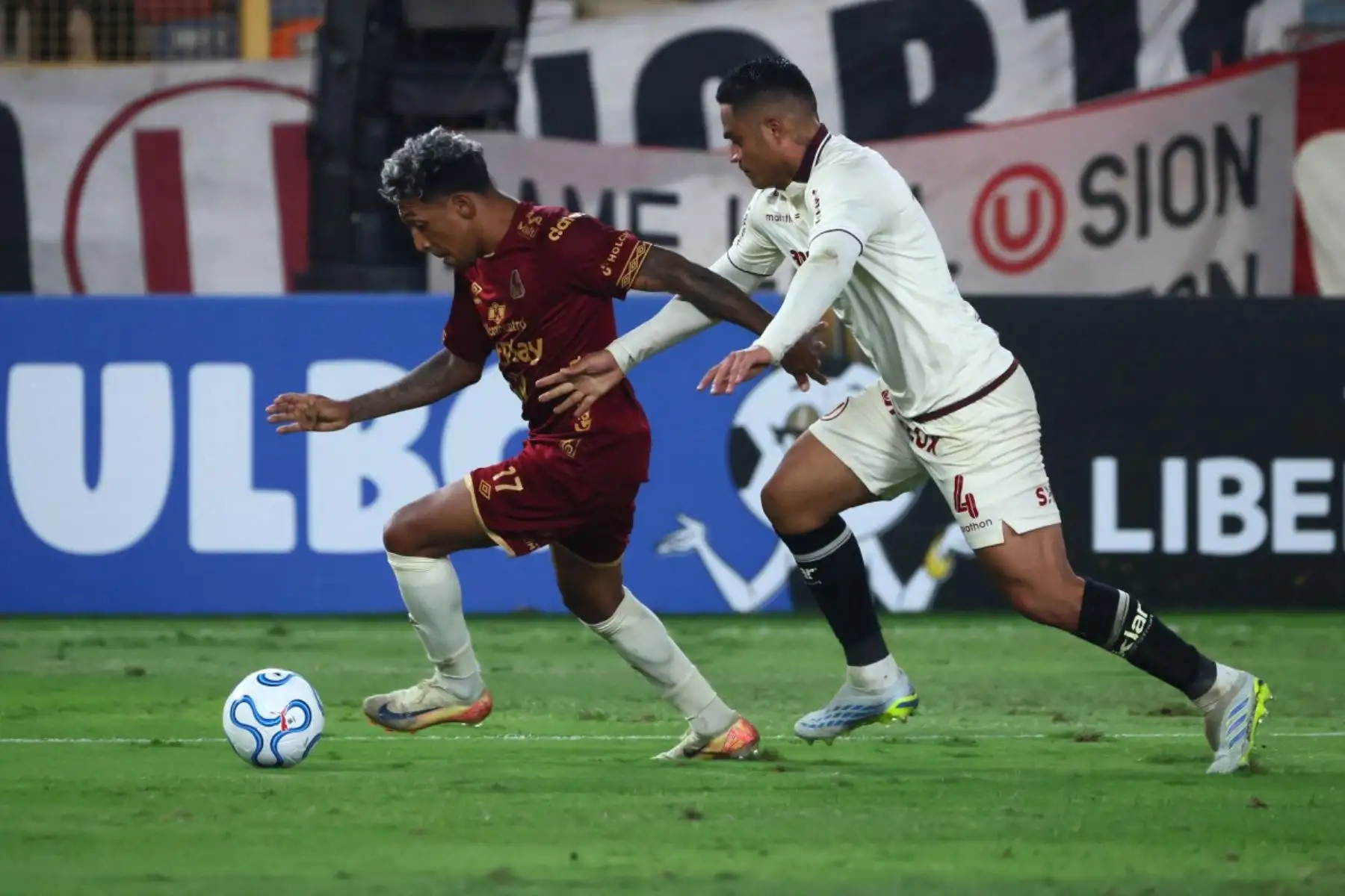 El defensor número 17 del Tolima, Cristian Arrieta (izquierda), y el defensor número 4 del Universitario, Anderson Santamaría, luchan por el balón durante el partido de la fase de grupos de la Copa Libertadores entre el Universitario de Perú y el Deportes Tolima de Colombia en el Estadio Monumental "U" Marathon de Lima, el 26 de mayo de 2026. (Foto de Connie FRANCE / AFP)