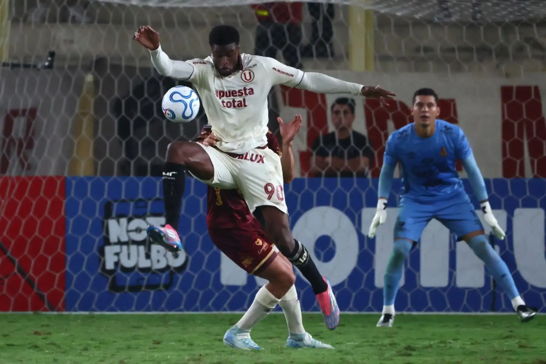 El delantero senegalés Sekou Gassama, número 90 del Universitario, y el defensa Jordan Osorio, número 71 del Tolima (no visible en la imagen), luchan por el balón durante el partido de la fase de grupos de la Copa Libertadores entre el Universitario de Perú y el Deportes Tolima de Colombia en el Estadio Monumental "U" Marathon de Lima, el 26 de mayo de 2026. (Foto de Connie FRANCE / AFP)