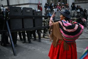 Una mujer protesta frente a la policía antidisturbios durante una marcha contra el gobierno de Rodrigo Paz. Bolivia, 27 de mayo de 2026. Foto: AFP