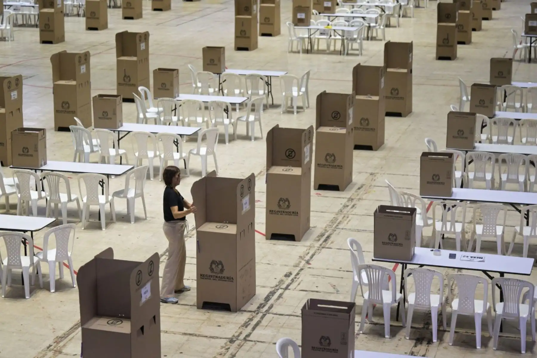 Un trabajador prepara las cabinas de votación en el Coliseo El Pueblo de Cali, departamento del Valle del Cauca, Colombia, el 30 de mayo de 2026, víspera de las elecciones presidenciales.
Los colombianos acuden a las urnas para unas elecciones presidenciales que enfrentarán visiones opuestas sobre cómo poner fin al medio siglo de conflicto en el país. Foto: AFP