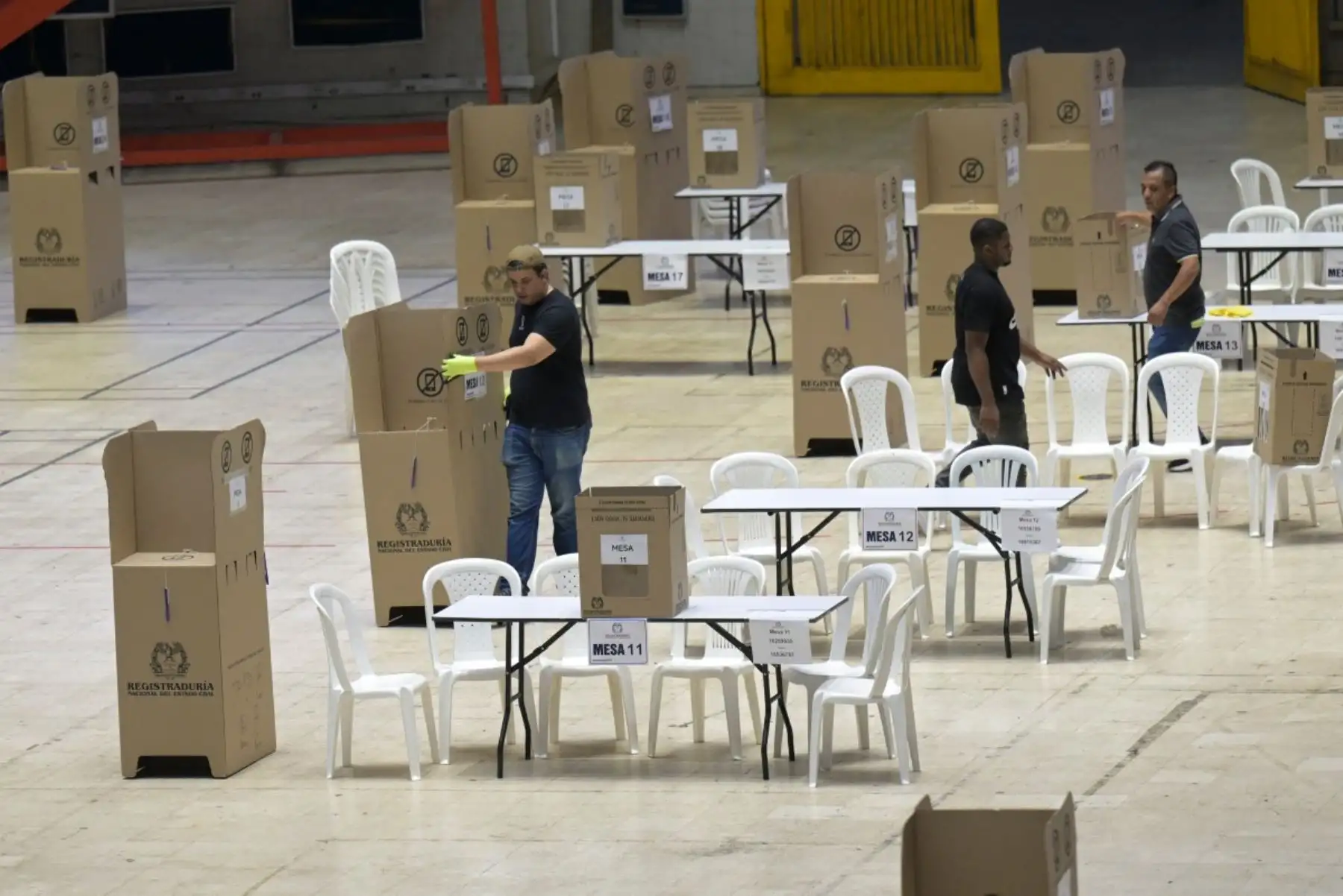 El 30 de mayo de 2026, en vísperas de las elecciones presidenciales, trabajadores colocan las cabinas de votación durante la preparación de un centro electoral en el Coliseo El Pueblo de Cali, departamento del Valle del Cauca, Colombia.
Los colombianos acuden a las urnas para unas elecciones presidenciales que enfrentarán visiones opuestas sobre cómo poner fin al medio siglo de conflicto que azota al país. Foto: AFP