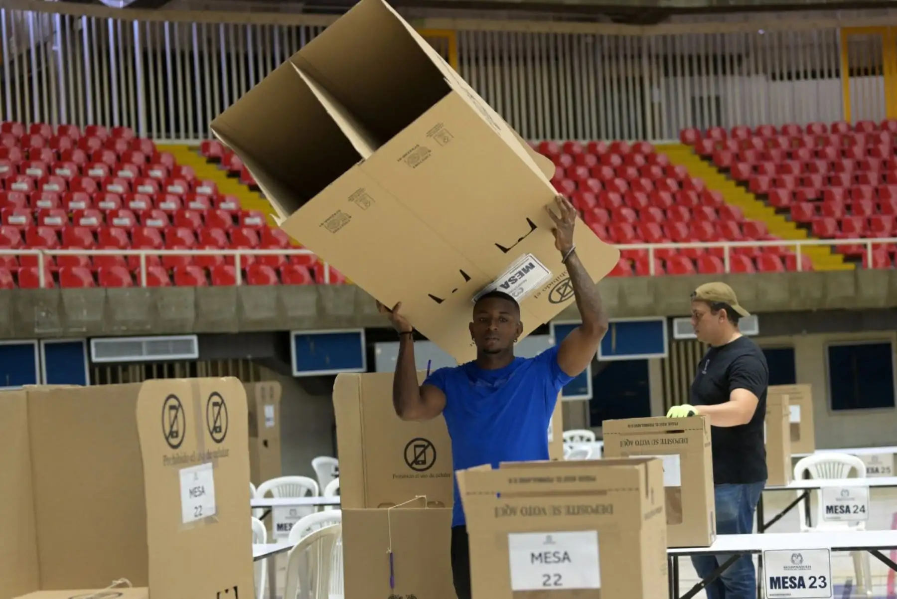 Un trabajador transporta una cabina de votación durante los preparativos en el Coliseo El Pueblo en Cali, departamento del Valle del Cauca, Colombia, el 30 de mayo de 2026, víspera de las elecciones presidenciales. Foto: AFP