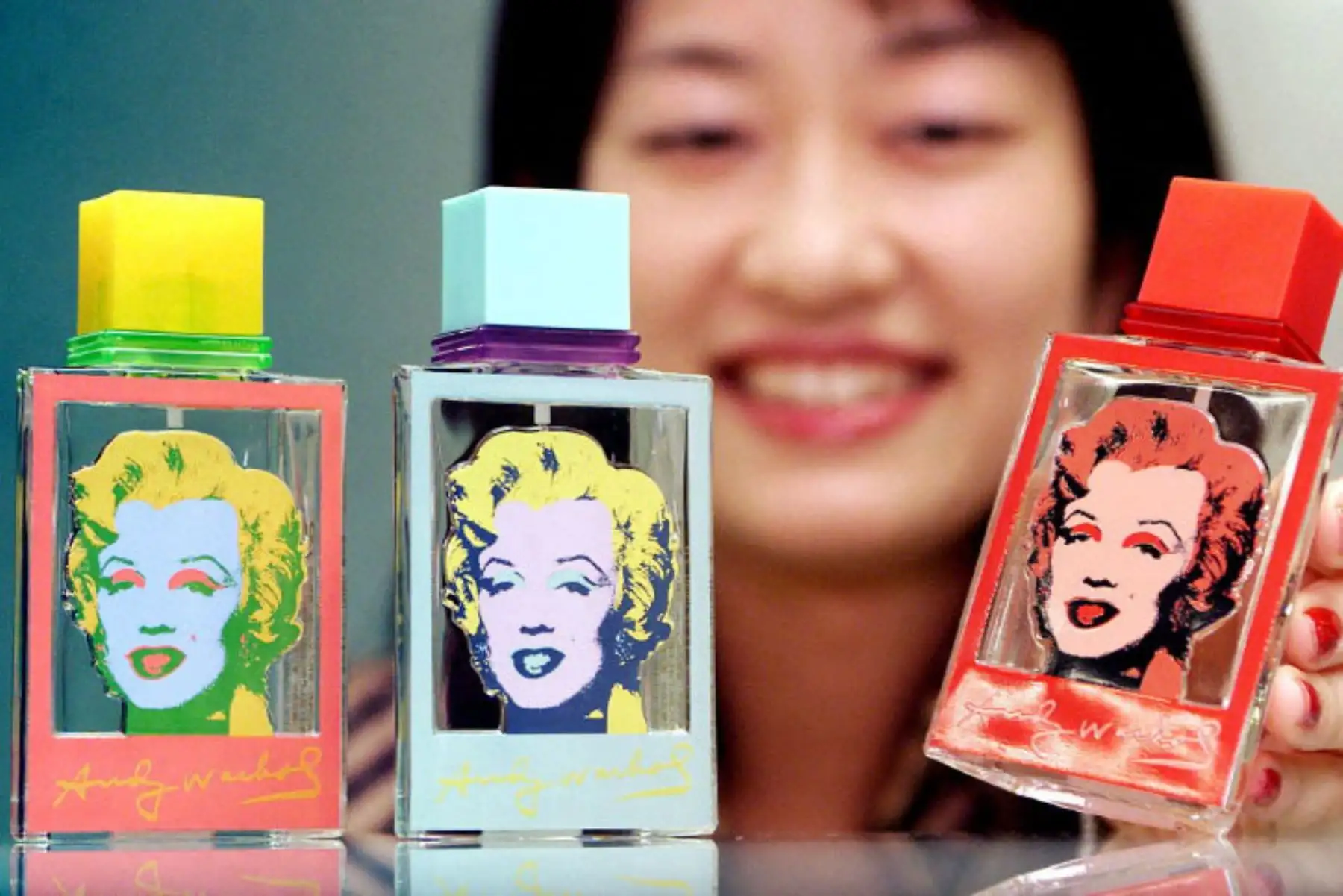 Seiko Kuwahata, empleada de la empresa japonesa de cosméticos Kanebo, muestra frascos de agua de tocador diseñados con la imagen de Marilyn Monroe de Andy Warhol en la sede de la compañía en Tokio, el 5 de noviembre de 2001.  Foto: AFP