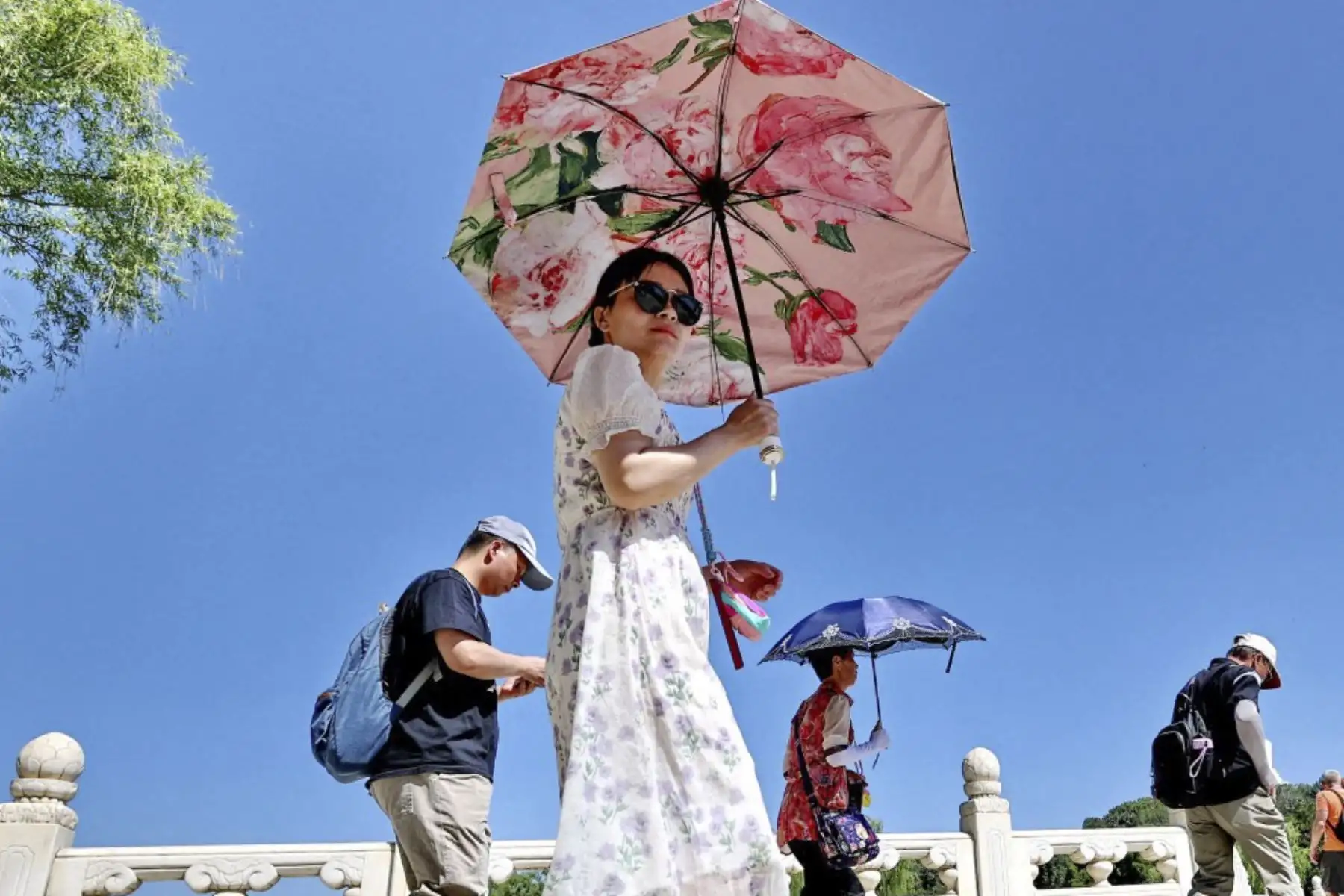 Los turistas visitan el Parque Beihai bajo un sol abrasador en Beijing, capital de China, mientras la temperatura llega a 35°C con una intensa radiación UV. (Foto de Shun Qiziran / foto IC / Imaginechina vía AFP)