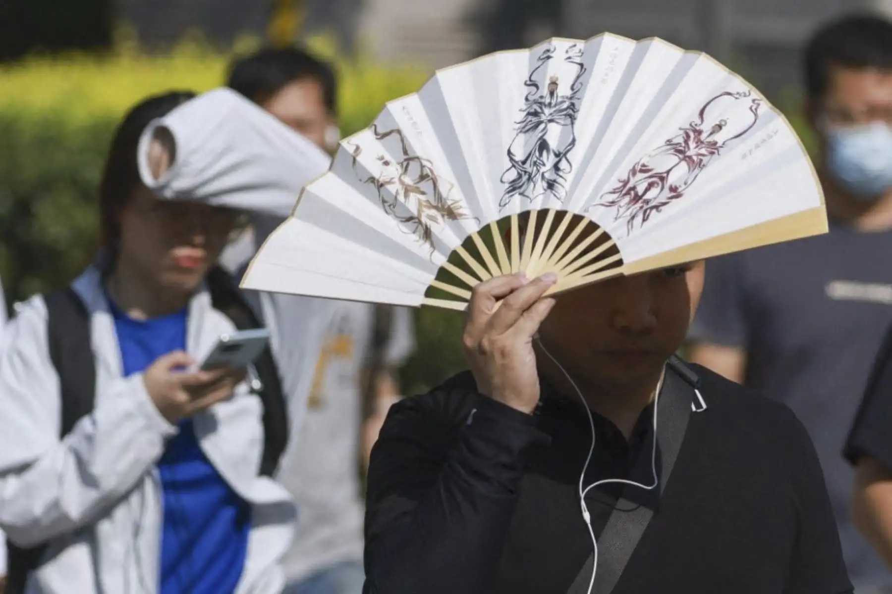 Los peatones caminan durante una ola de calor en Beijing, el 2 de junio de 2026, ya que las temperaturas superan los 35°C. (Foto de cnsphoto / Imaginechina vía AFP)