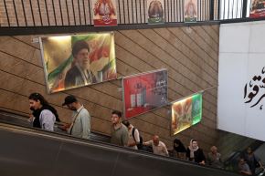 Usuarios del metro de Teherán avanzan por una escalera mecánica bajo a una fotografía del asesinado líder supremo, ayatolá Ali Khamenei, el 3 de junio de 2026. Foto: AFP