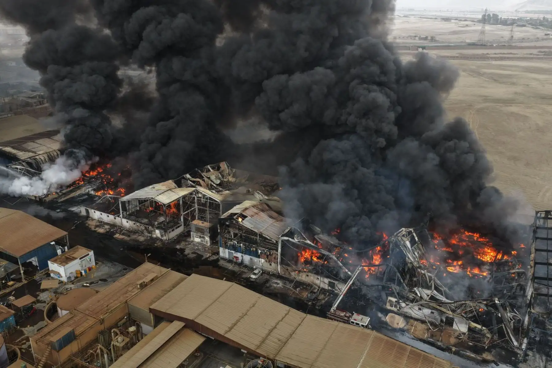 Una densa columna de humo se eleva desde una fábrica de Lurín afectada por un incendio. Vecinos y trabajadores alertan sobre el fuerte olor que emana de la zona mientras continúan las labores de emergencia. Foto: ANDINA/ Juan Carlos Guzmán