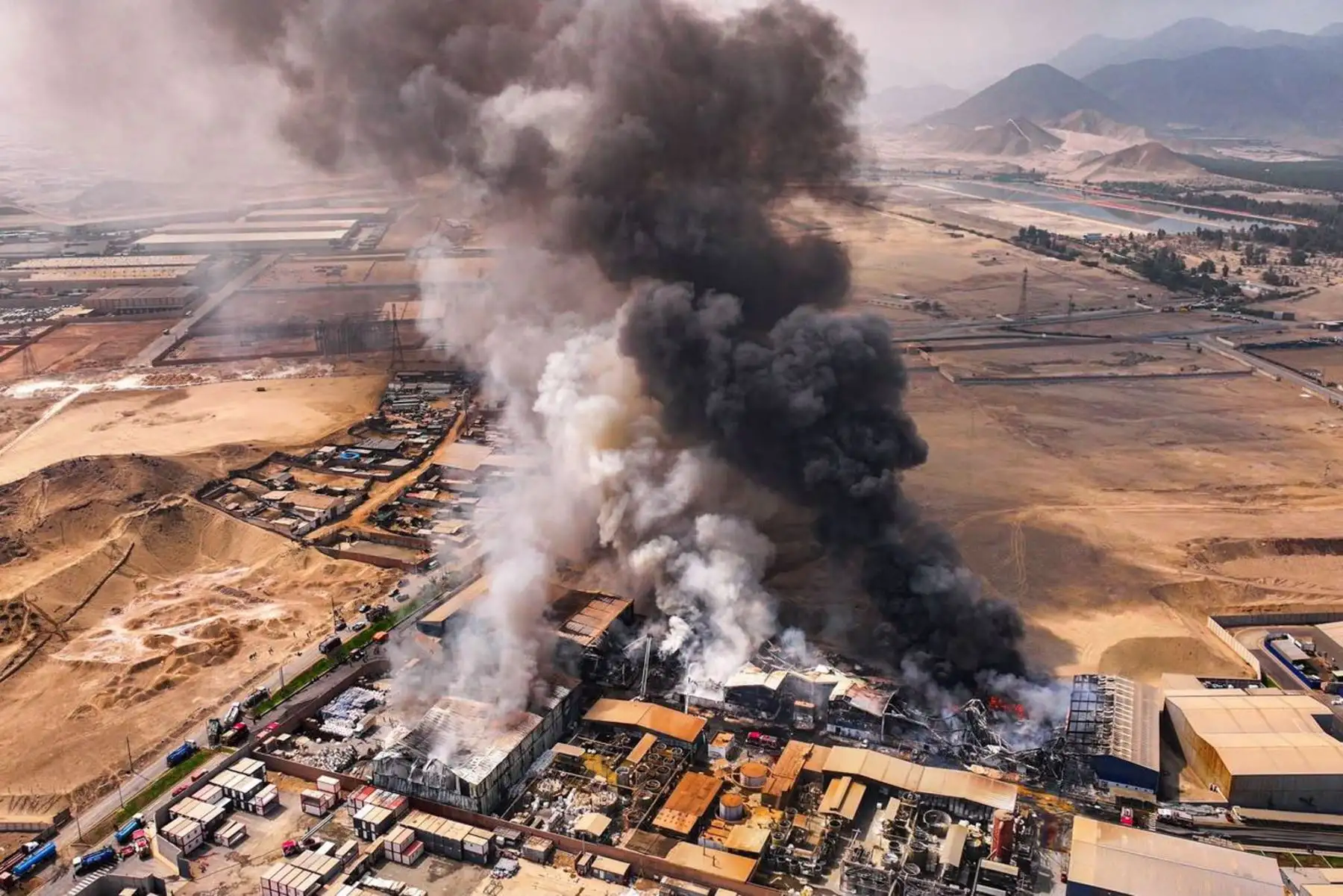 Una columna de humo se eleva sobre la zona industrial de Lurín durante las labores de control del incendio de grandes proporciones. Foto: Ricardo Cuba.